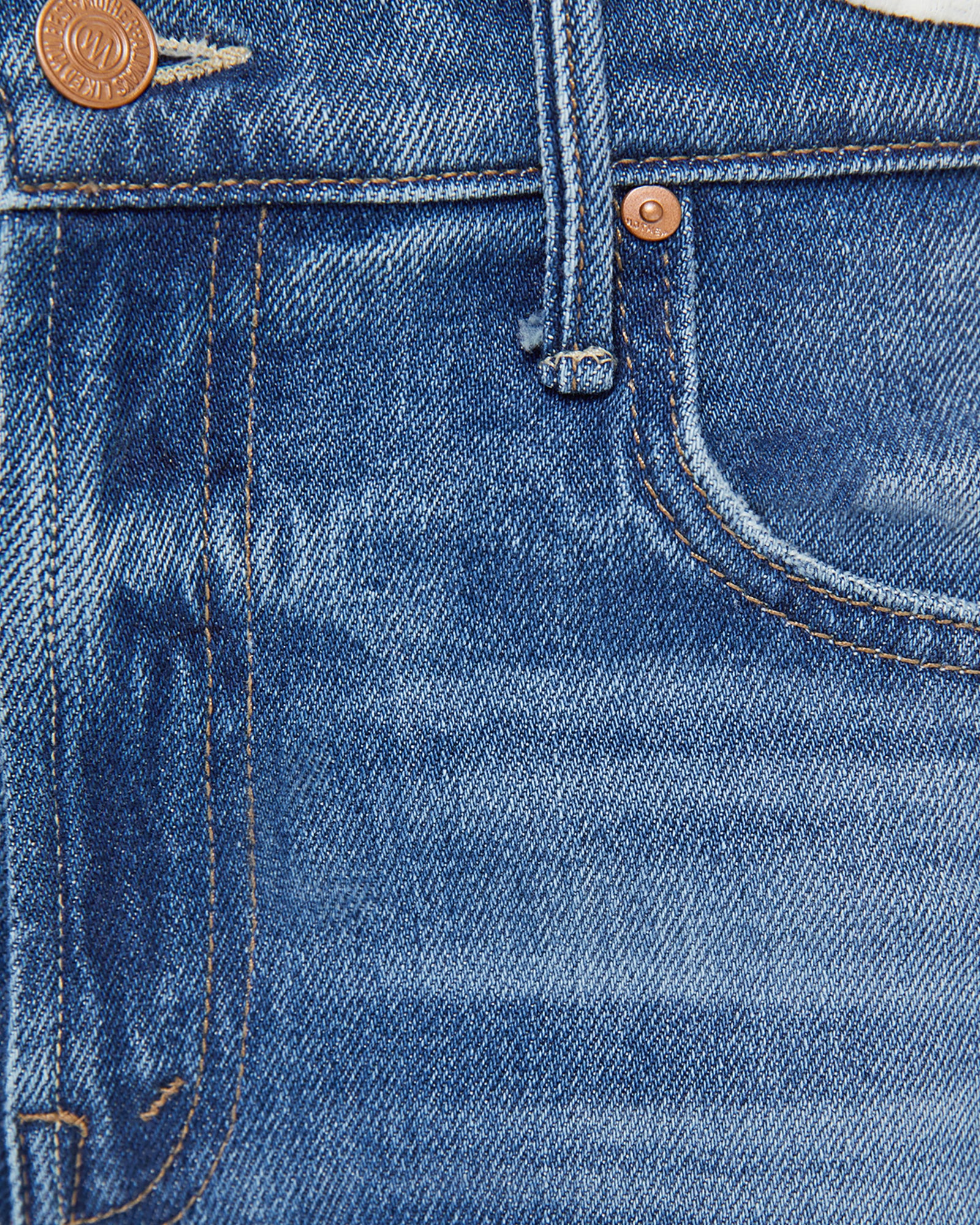 Close-up of blue denim jeans with button and stitching details