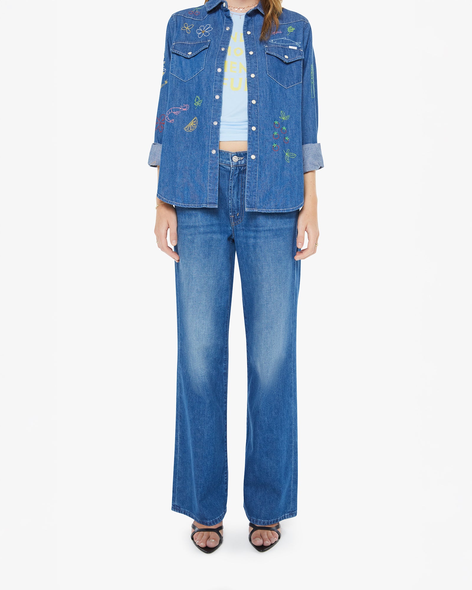 Person wearing a denim outfit with a jacket and jeans on a white background