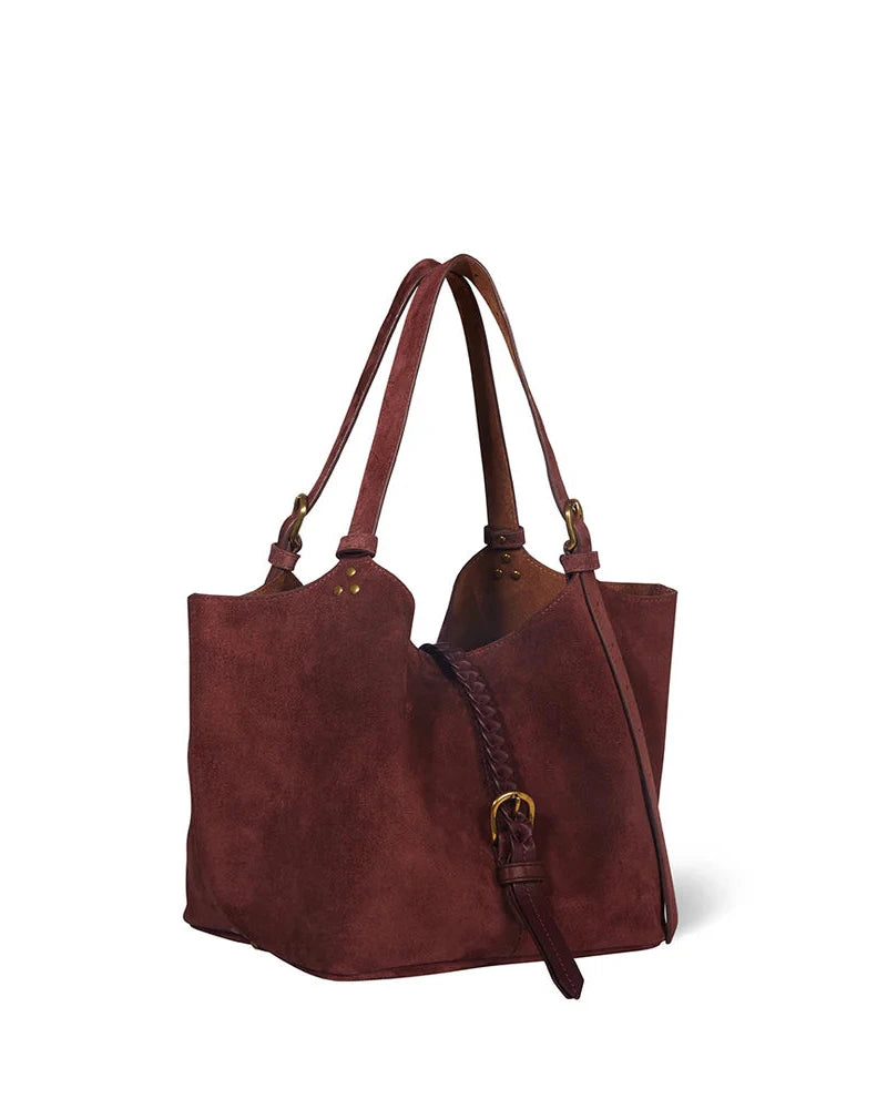 Brown suede handbag with a strap on a white background