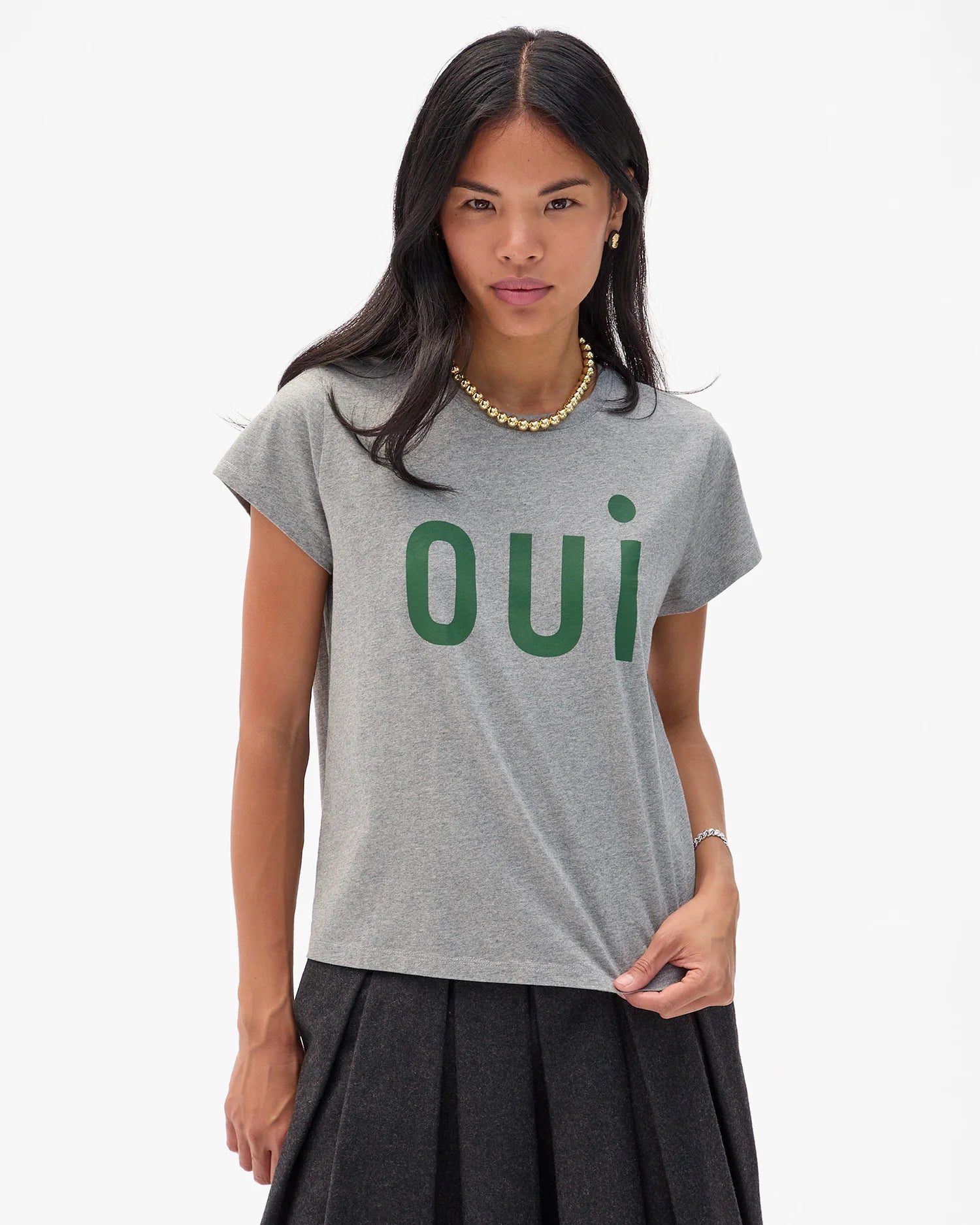 Woman wearing a gray t-shirt with 'oui' printed in green on a white background