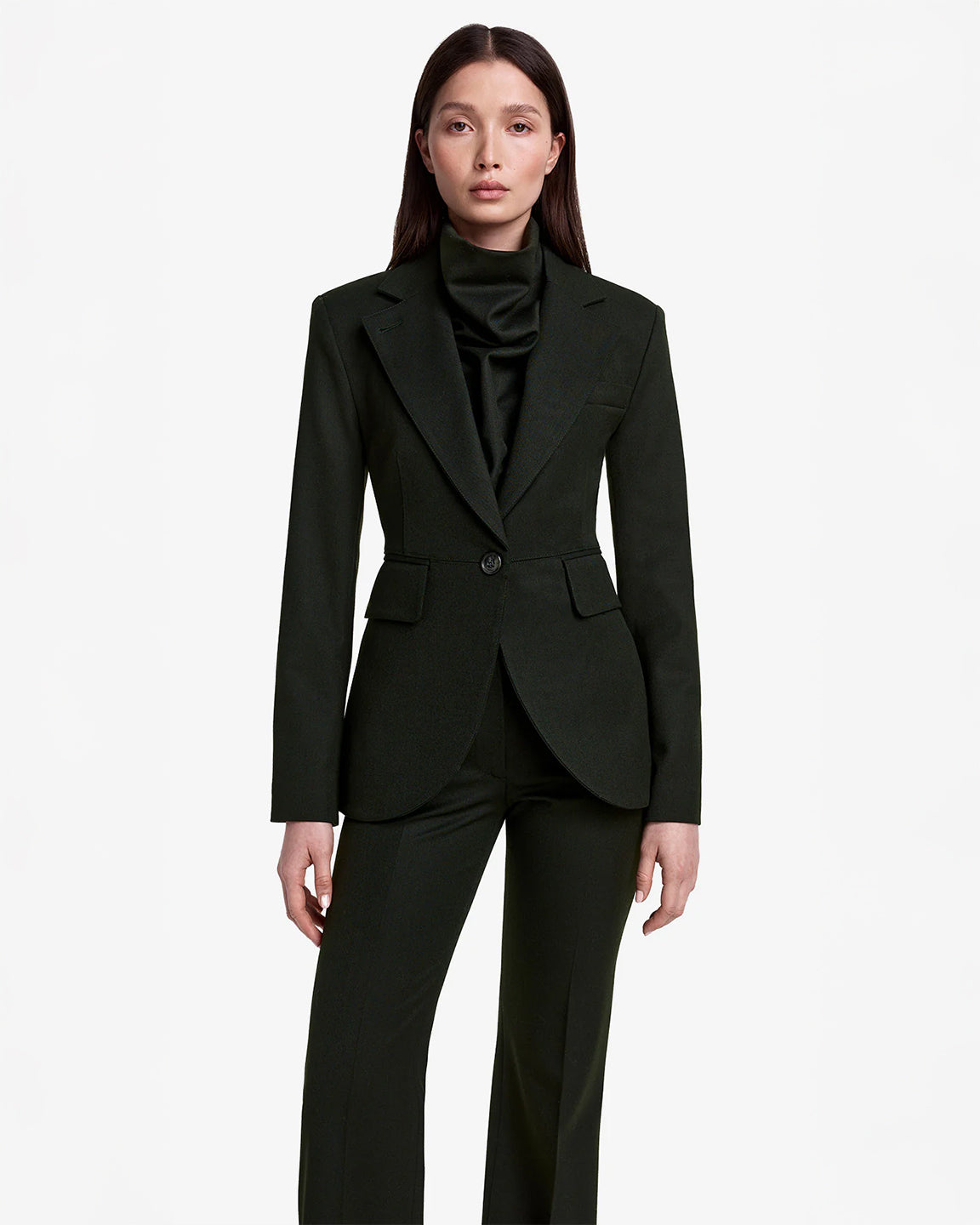 Woman wearing a dark green suit on a white background
