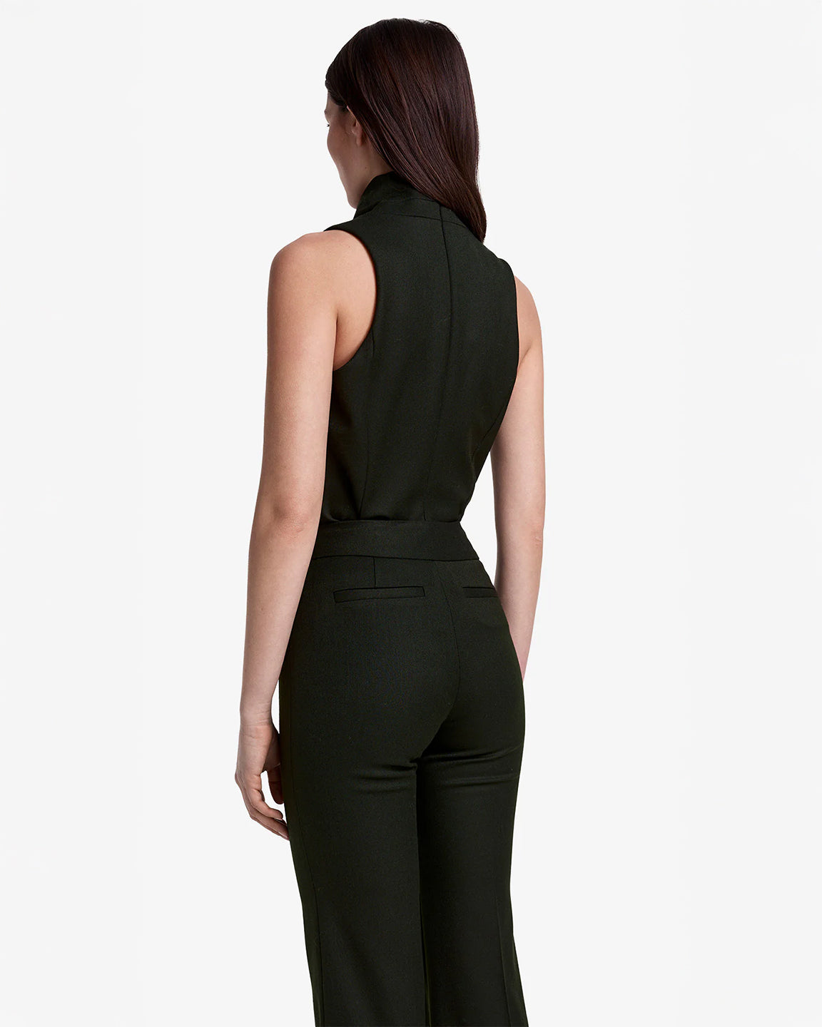 Woman wearing a black sleeveless top and pants on a white background