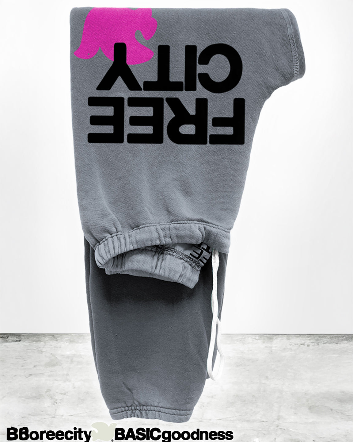 Gray sweatpants with 'FREE CITY' text and pink logo on a white background