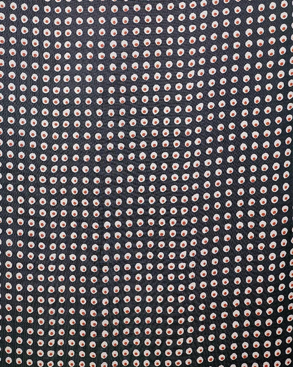 A close-up of a fabric pattern featuring a dense grid of small, circular motifs in light pink and white on a very dark charcoal or black background.