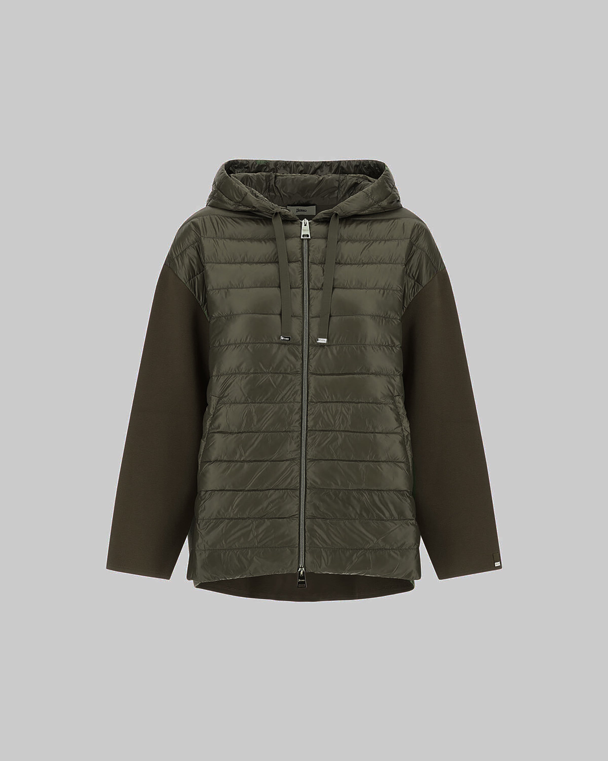 Green quilted jacket with a hood on a gray background
