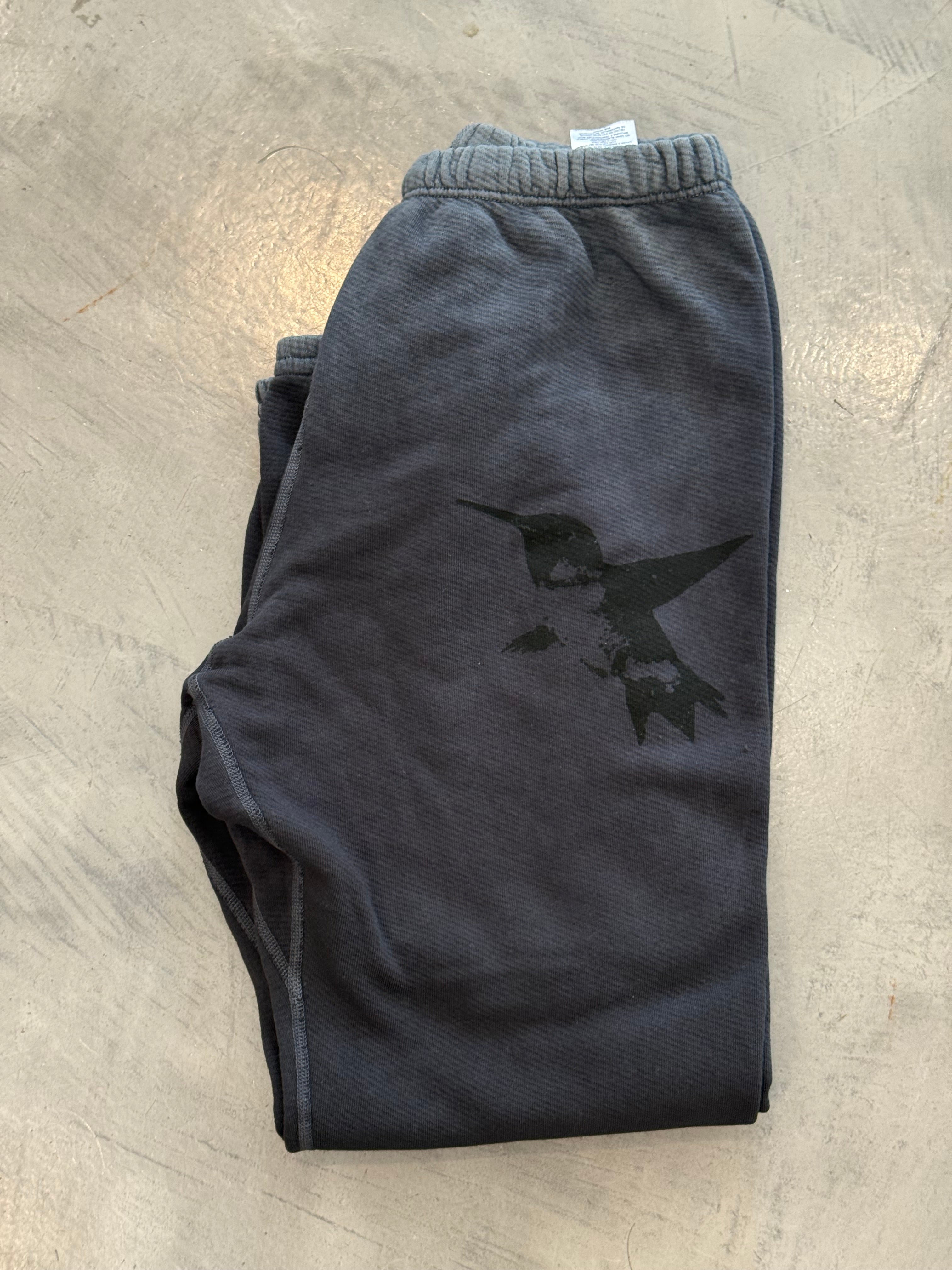 Folded black shorts with a logo on a light wooden surface