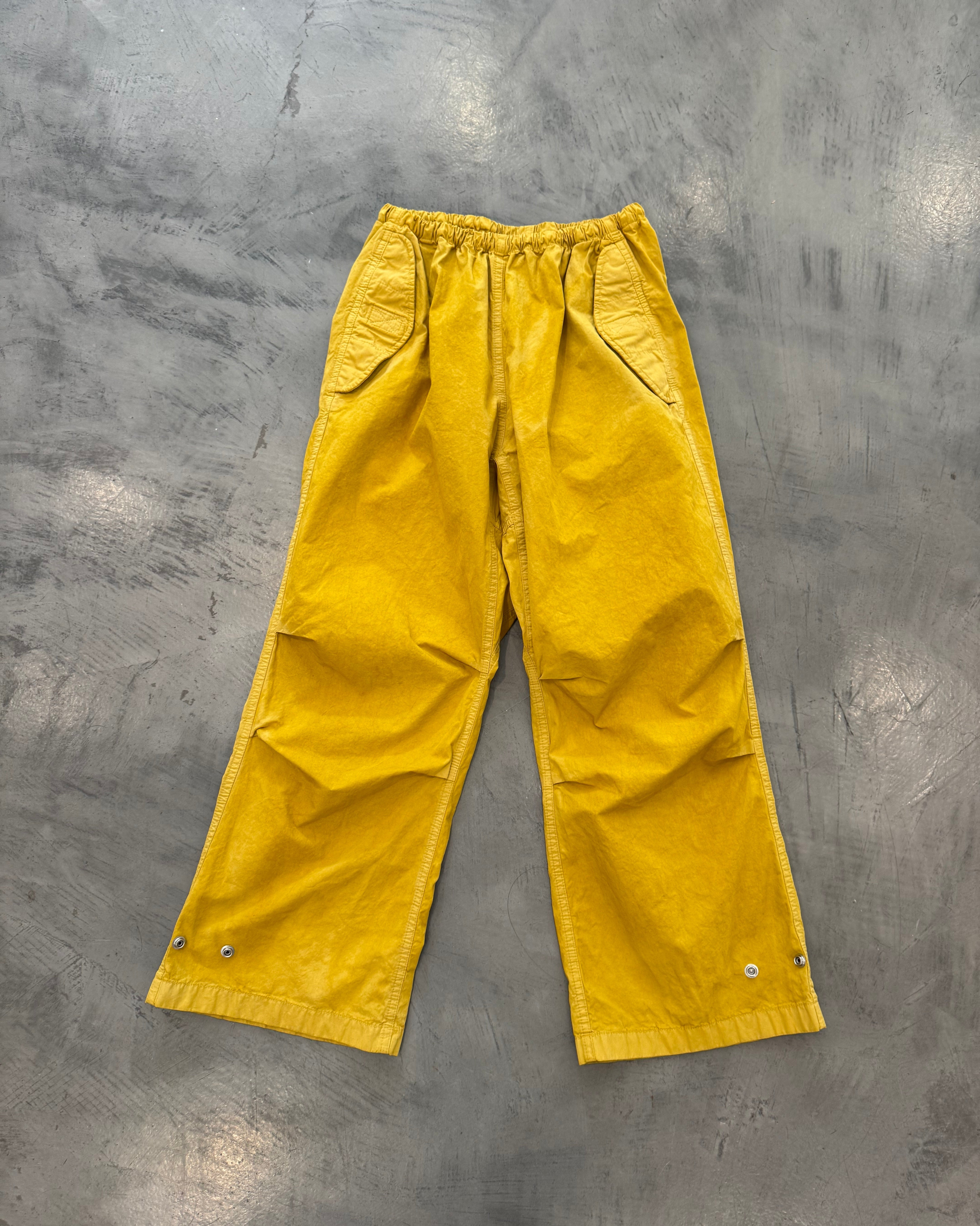 Yellow pants on a gray concrete floor
