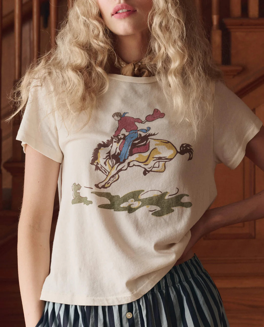 Person wearing a t-shirt with a graphic design of a person riding a horse.