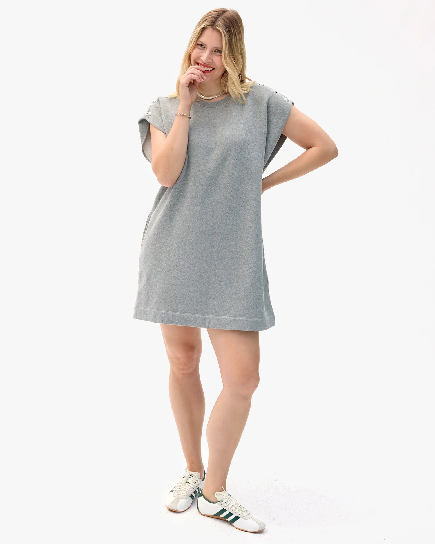 Woman wearing a gray t-shirt dress on a white background