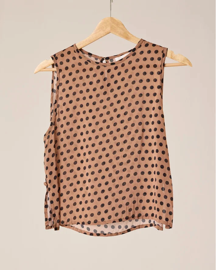 Brown sleeveless top with black polka dots on a beige background