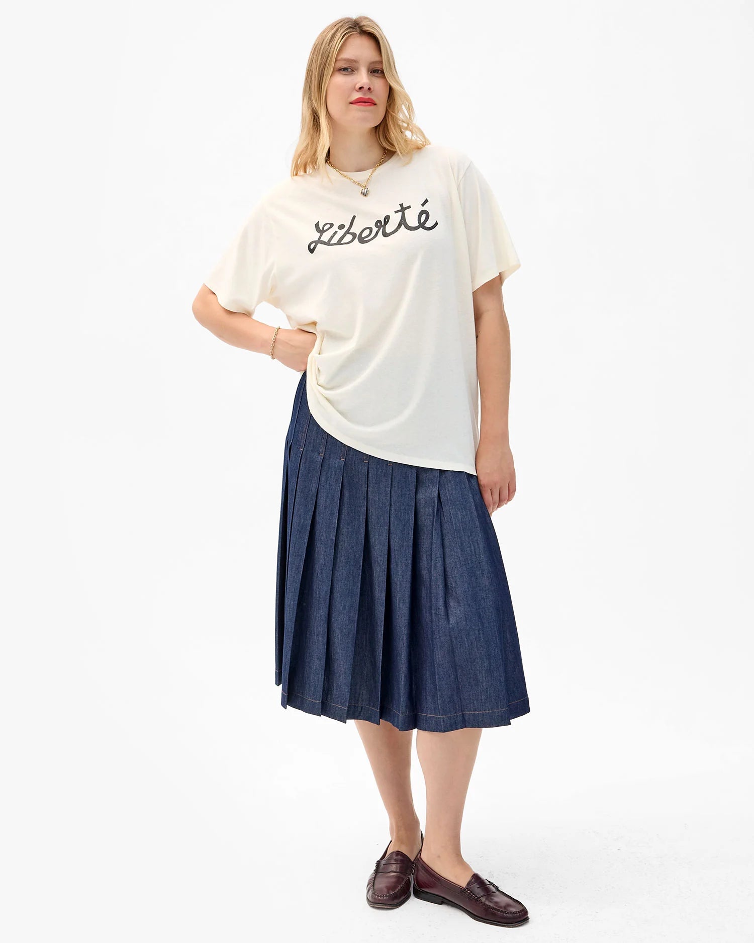Woman wearing a white t-shirt with text and a blue skirt on a white background