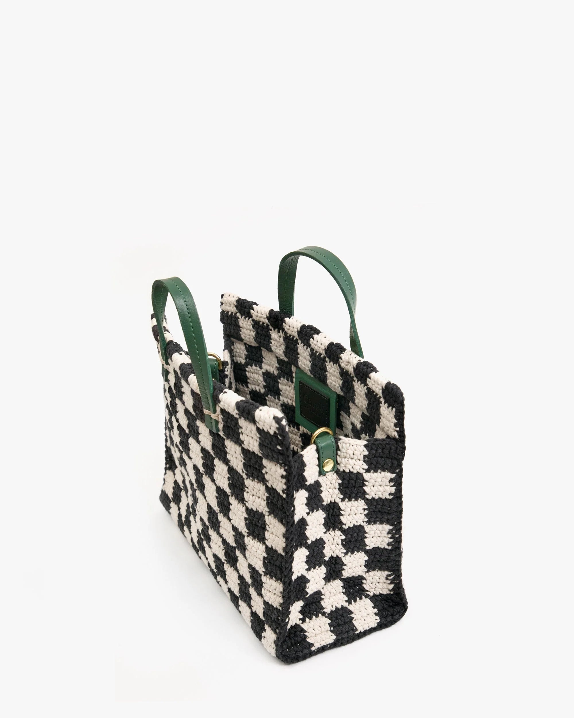 Black and white checkered bag with green handles on a white background