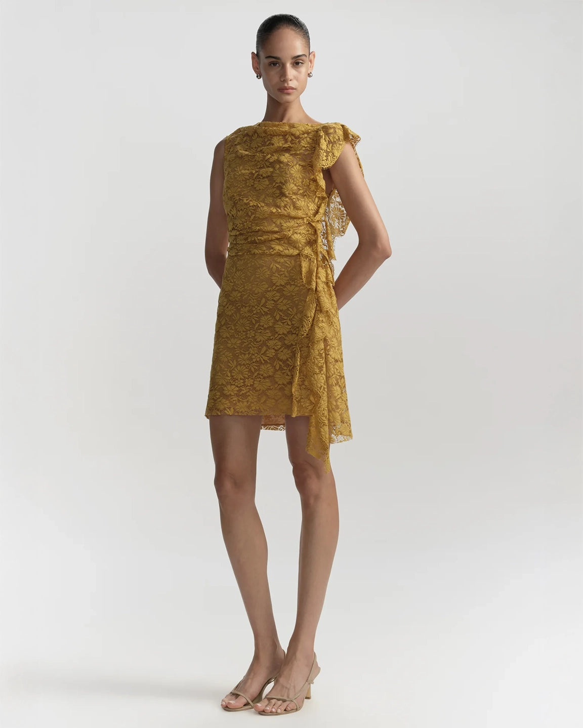 Woman wearing a gold dress on a white background