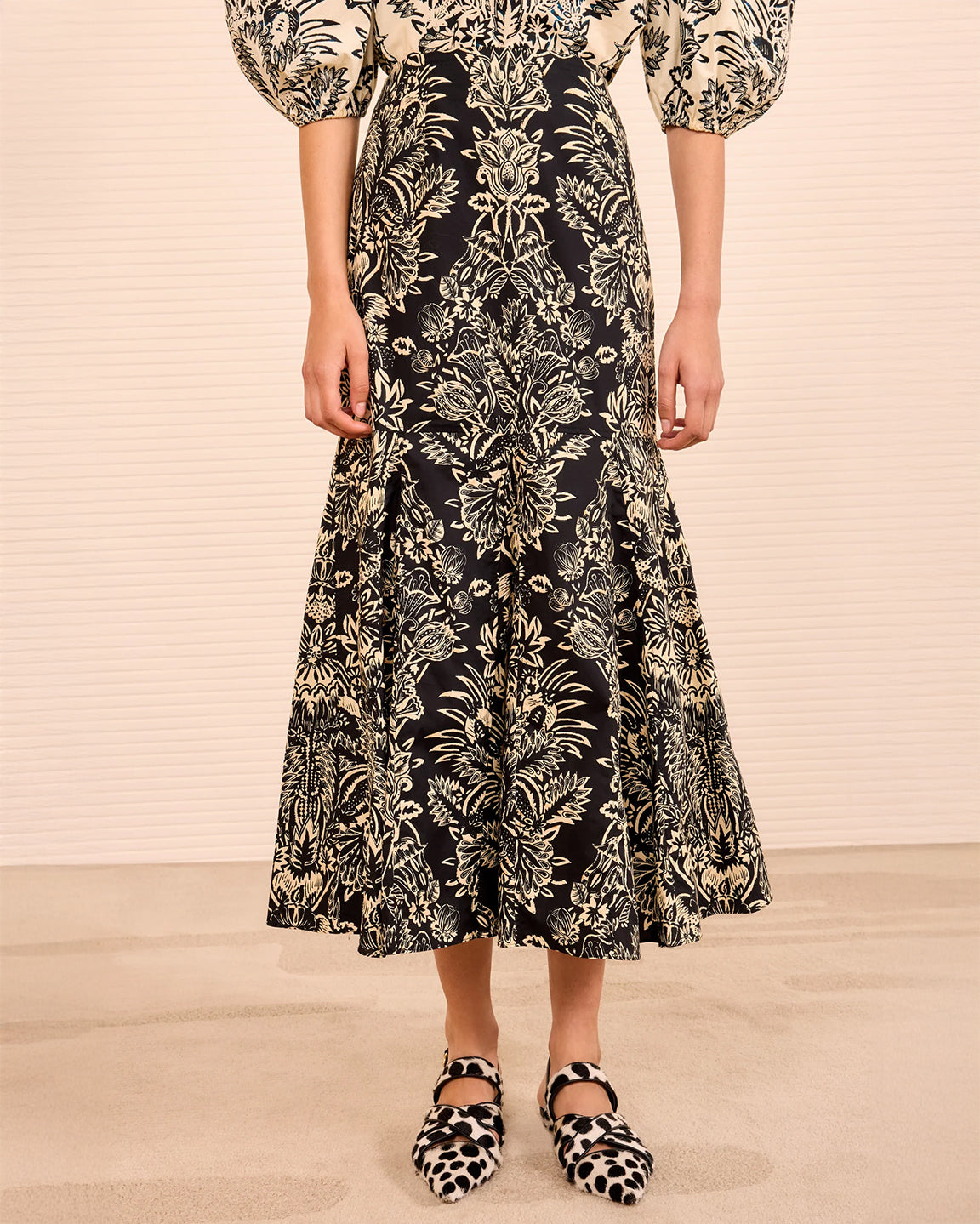 Person wearing a black floral dress with white background