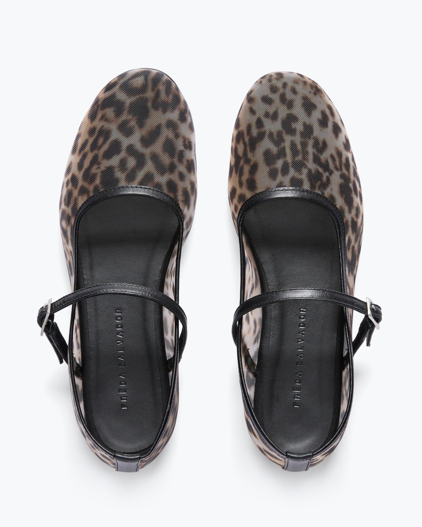 Pair of leopard print shoes with black straps on a white background