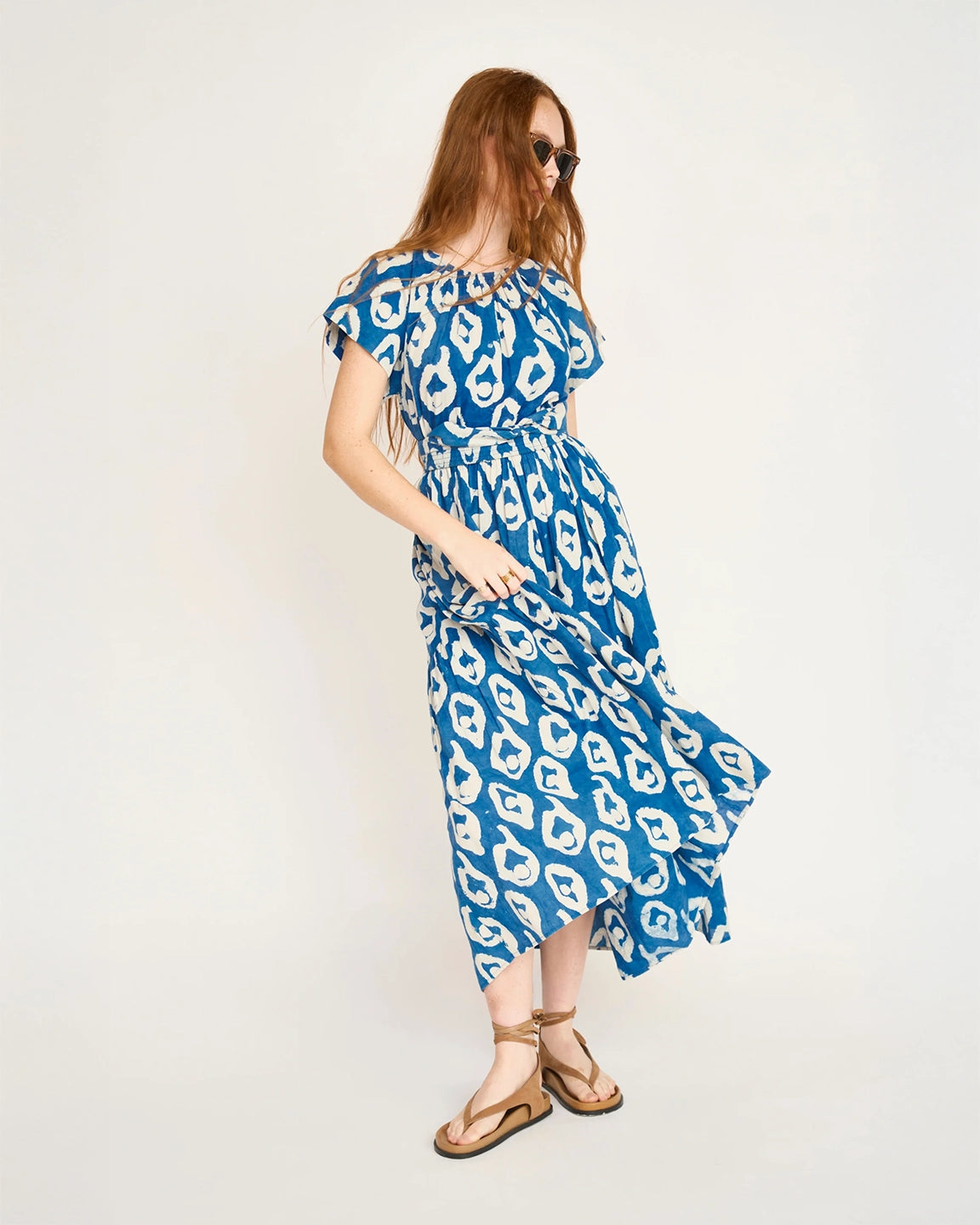 Woman wearing a blue and white patterned dress on a white background