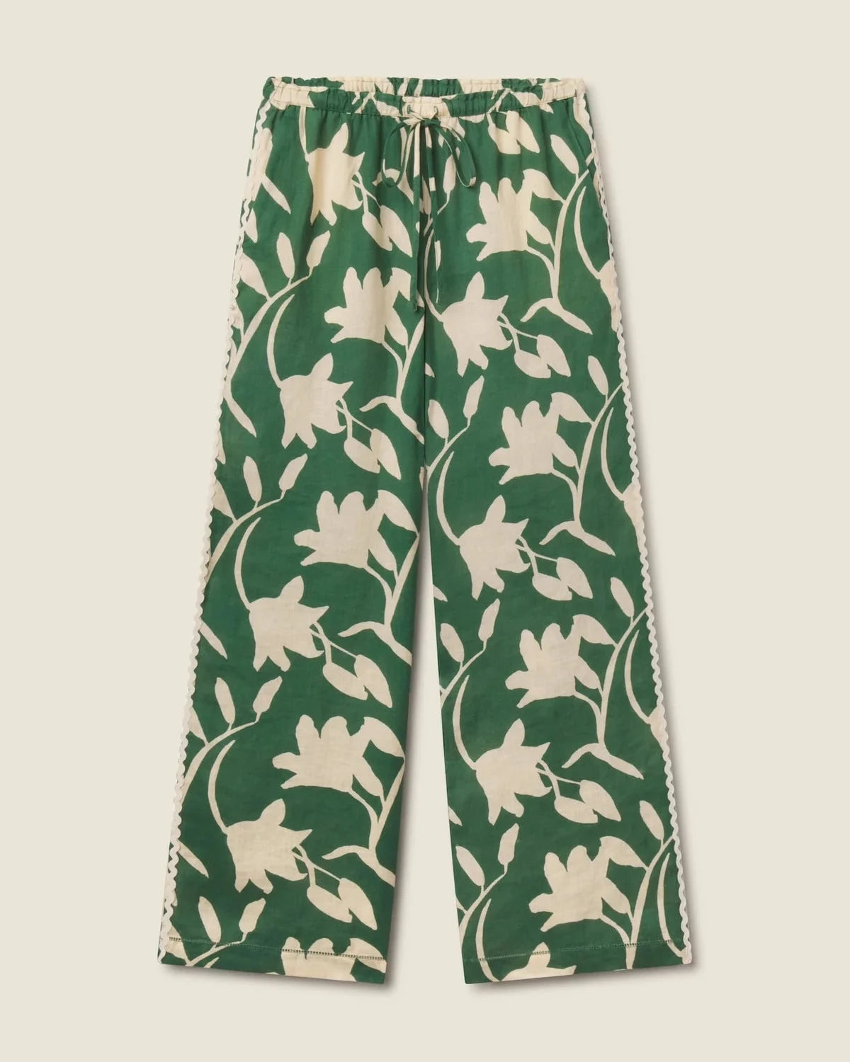 Green and white floral-patterned pants on a beige background