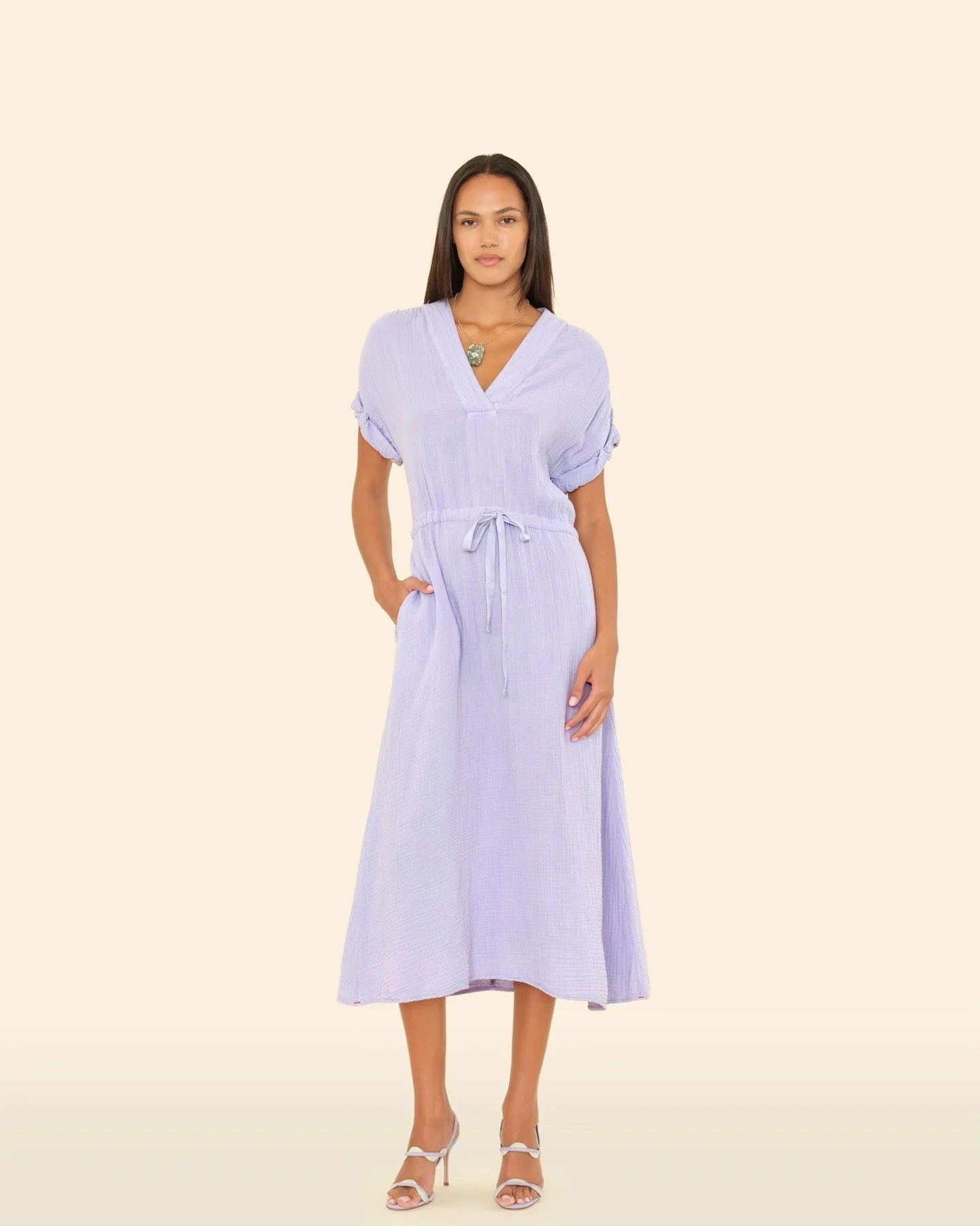 Woman wearing a light purple dress on a beige background