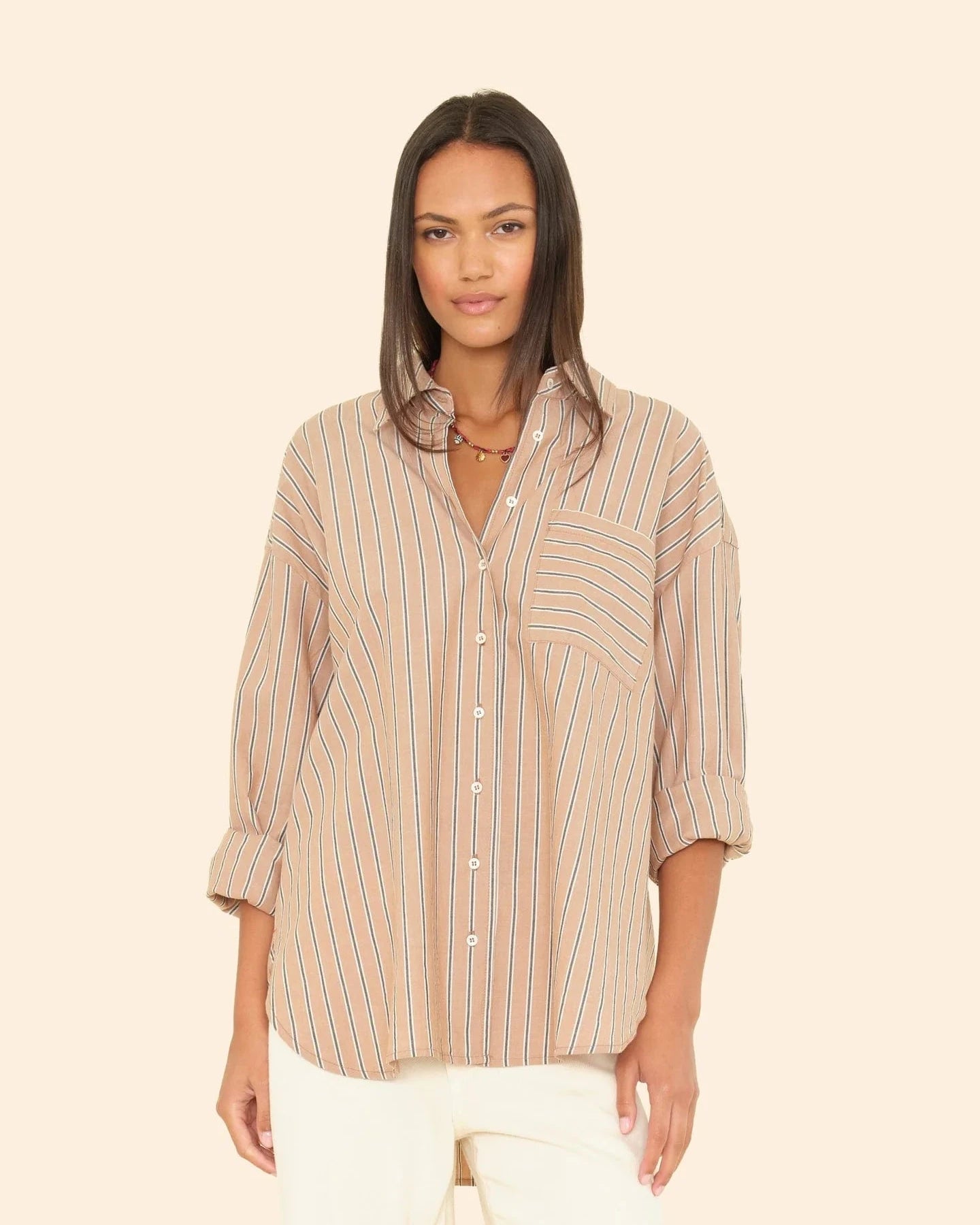 Woman wearing a striped shirt against a beige background