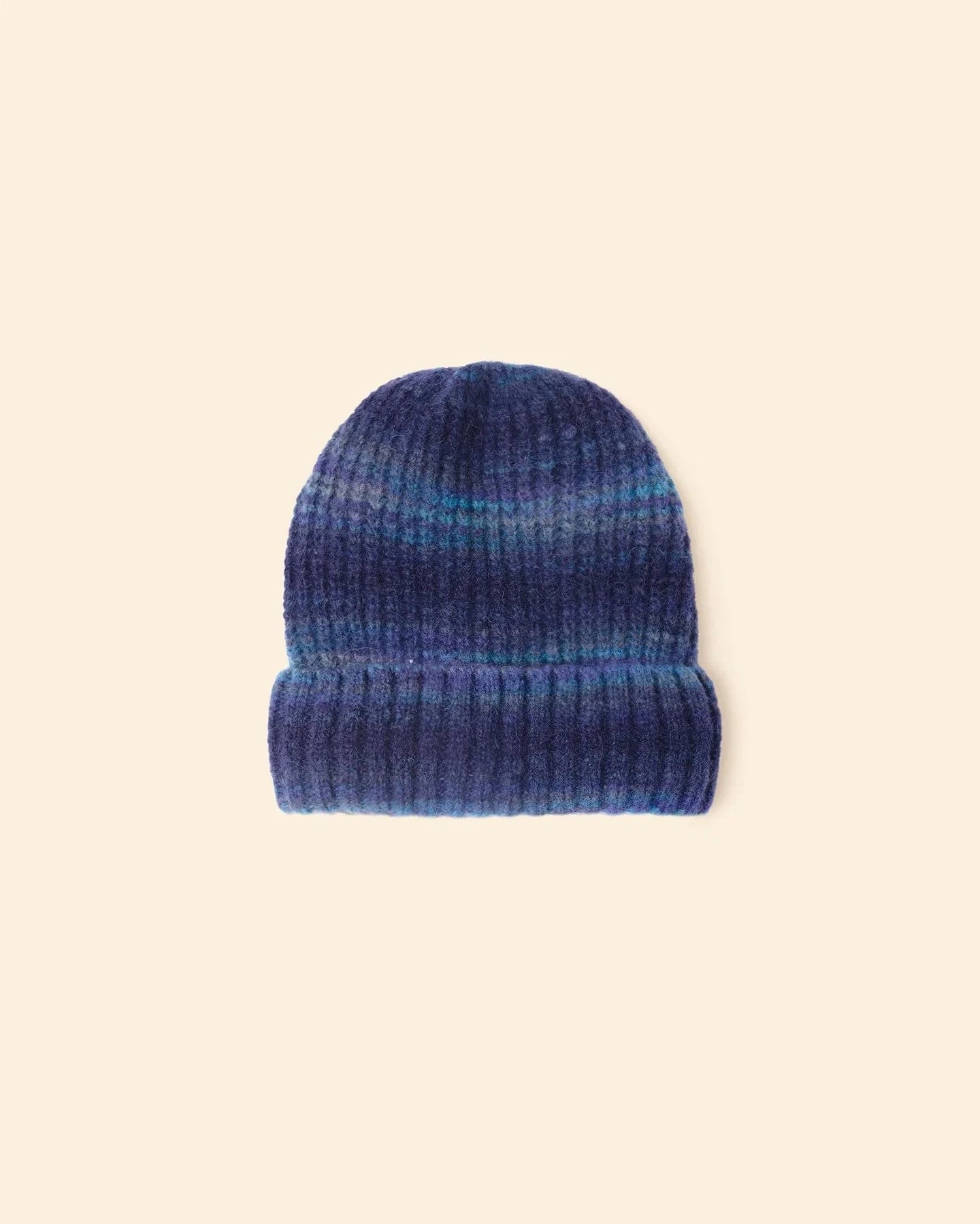 Blue ribbed knit beanie on a beige background