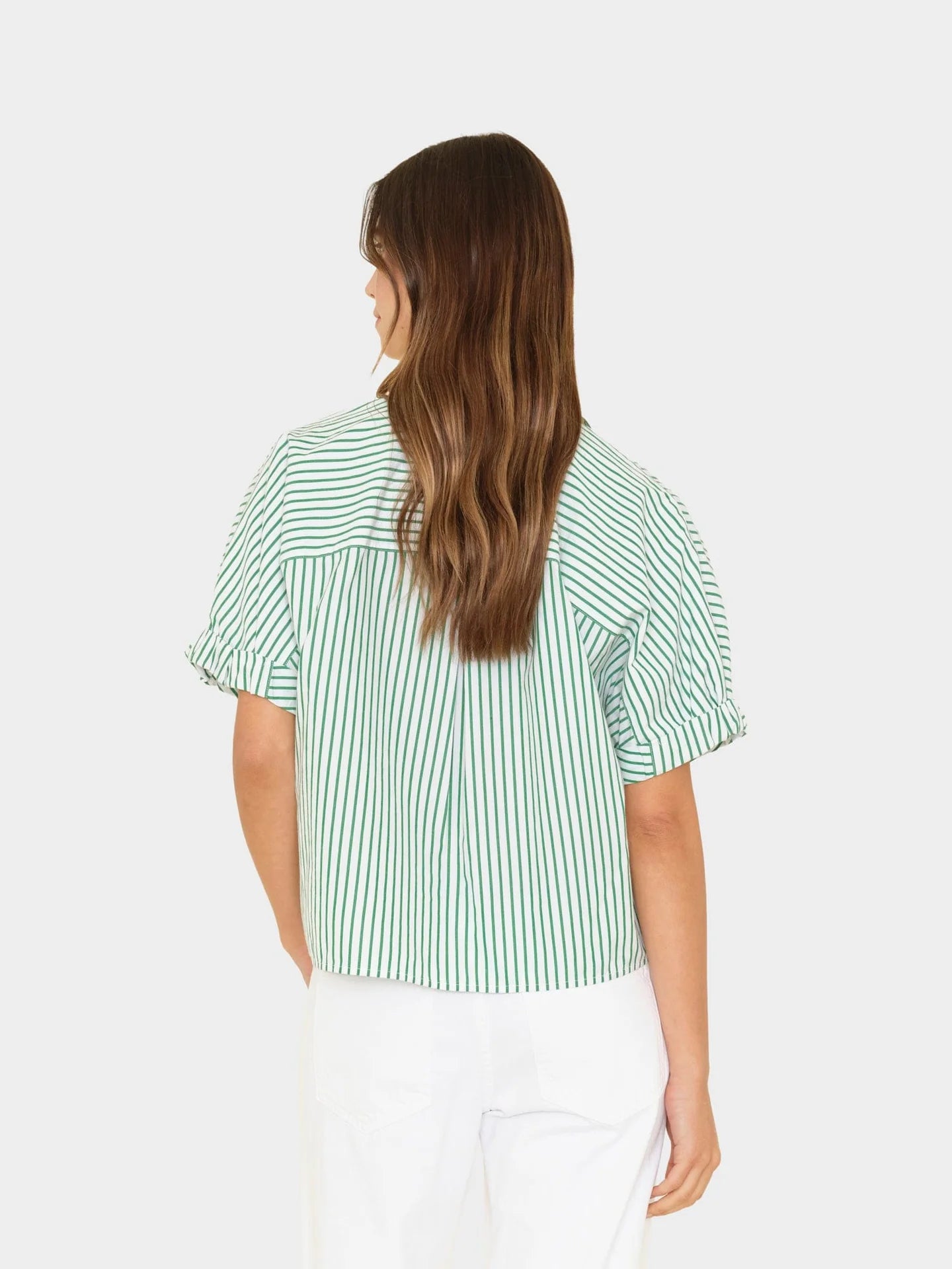 Woman wearing a green and white striped shirt on a white background