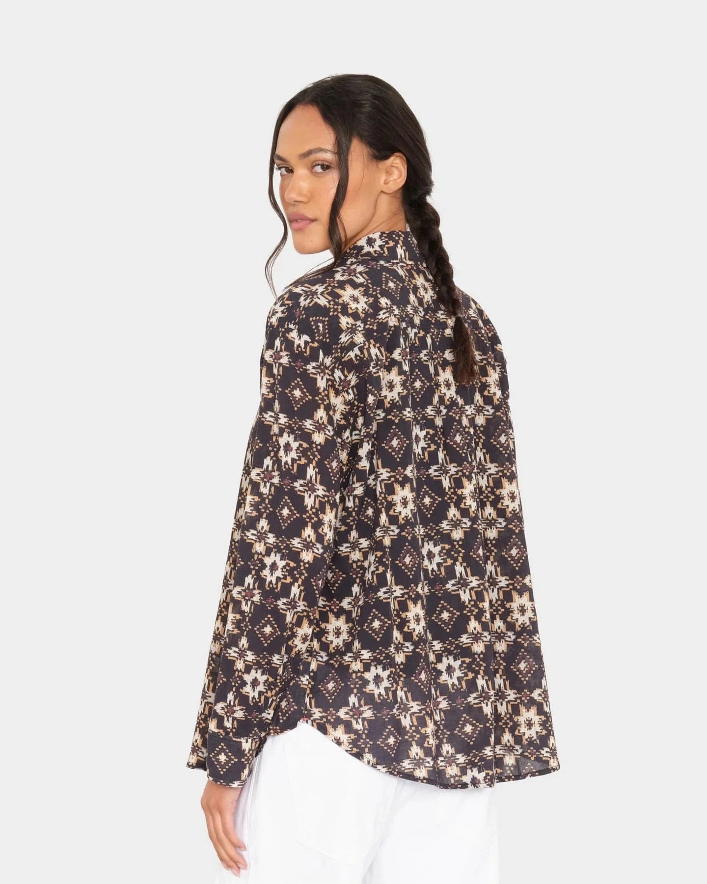 Woman wearing a patterned shirt on a white background