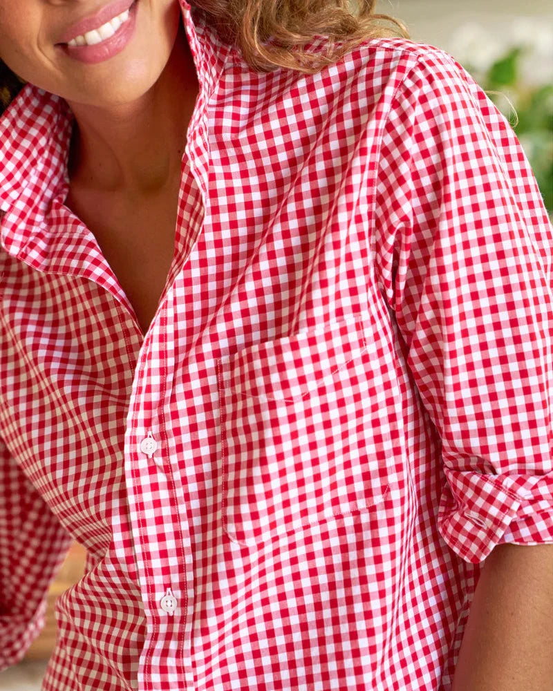 Person wearing a red and white checkered shirt with a blurred background