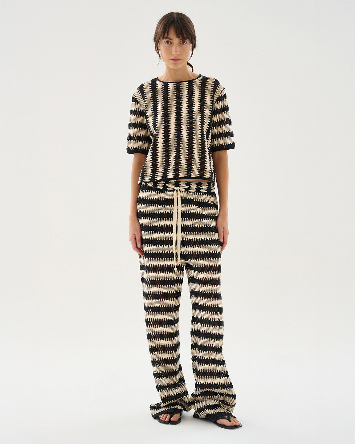 Person wearing a black and white striped outfit on a white background