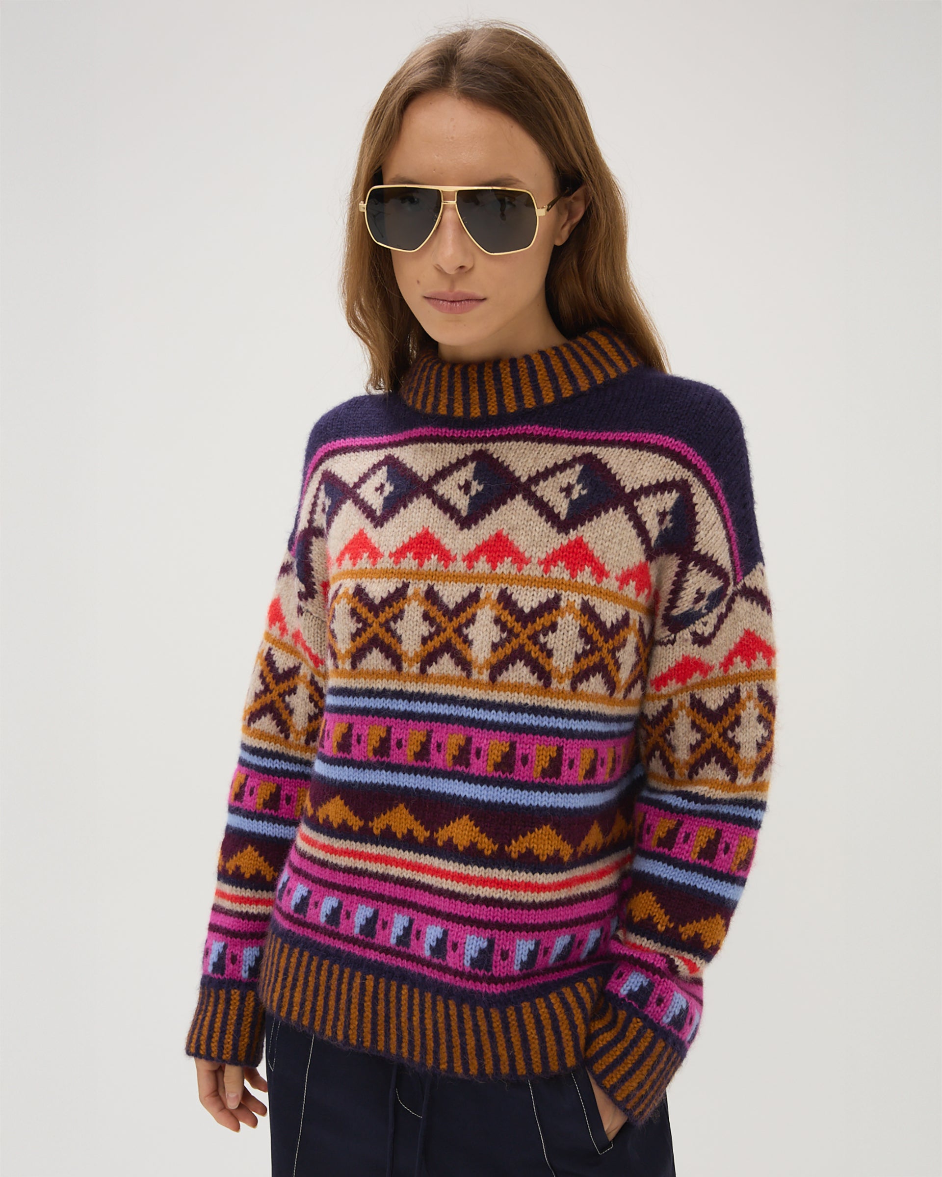 Person wearing a colorful patterned sweater on a plain background