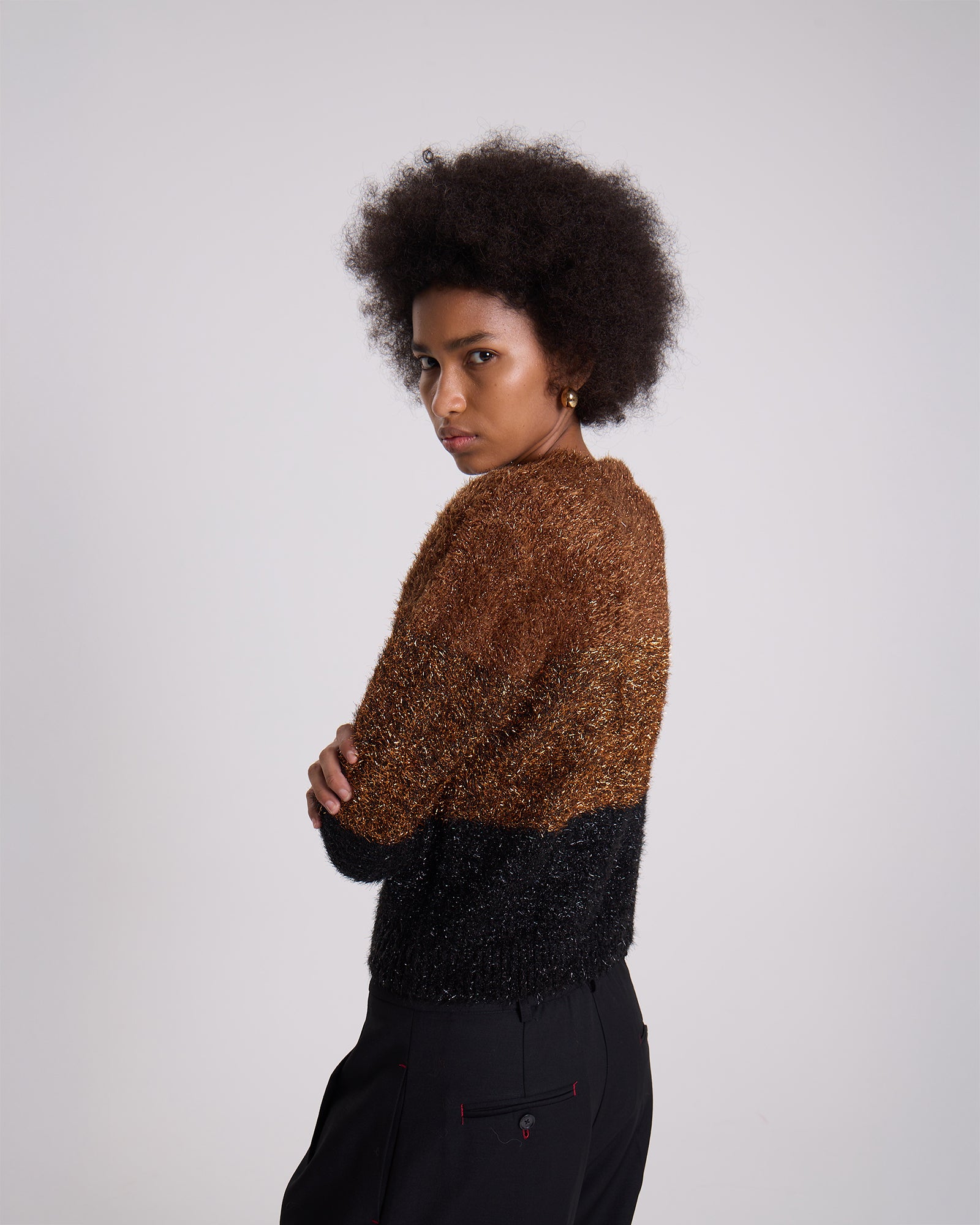 Person wearing a two-tone sweater with a plain background