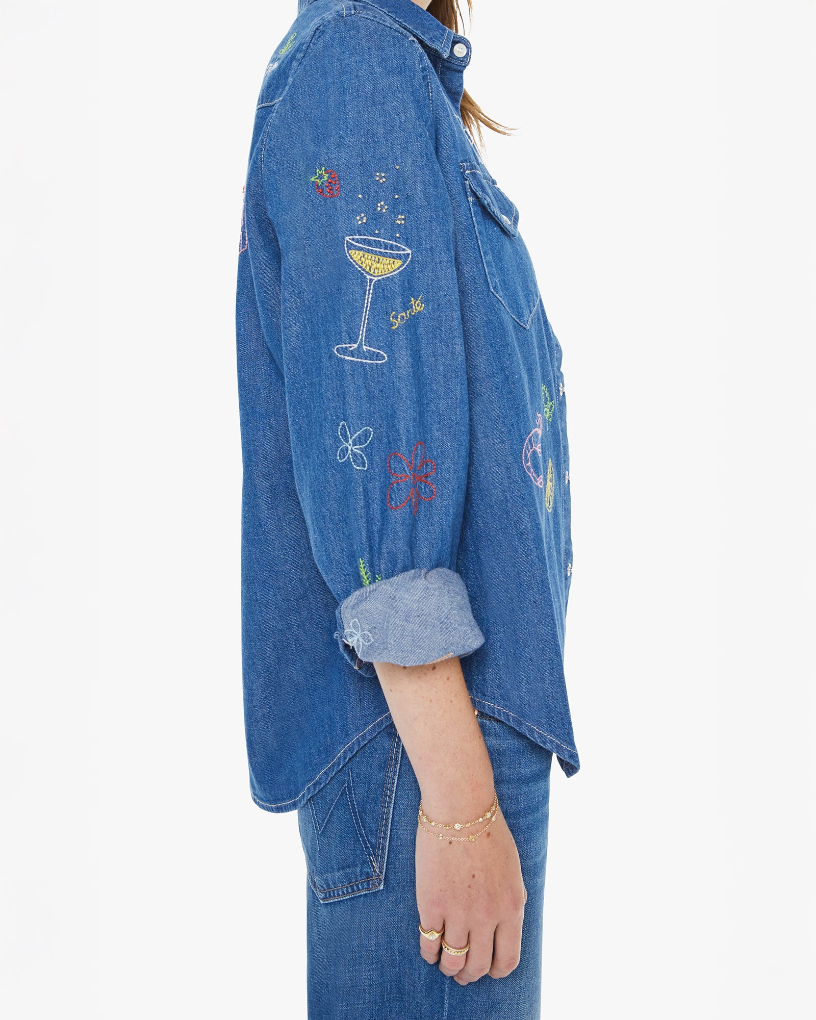 Blue denim jacket with floral and cocktail designs on a white background
