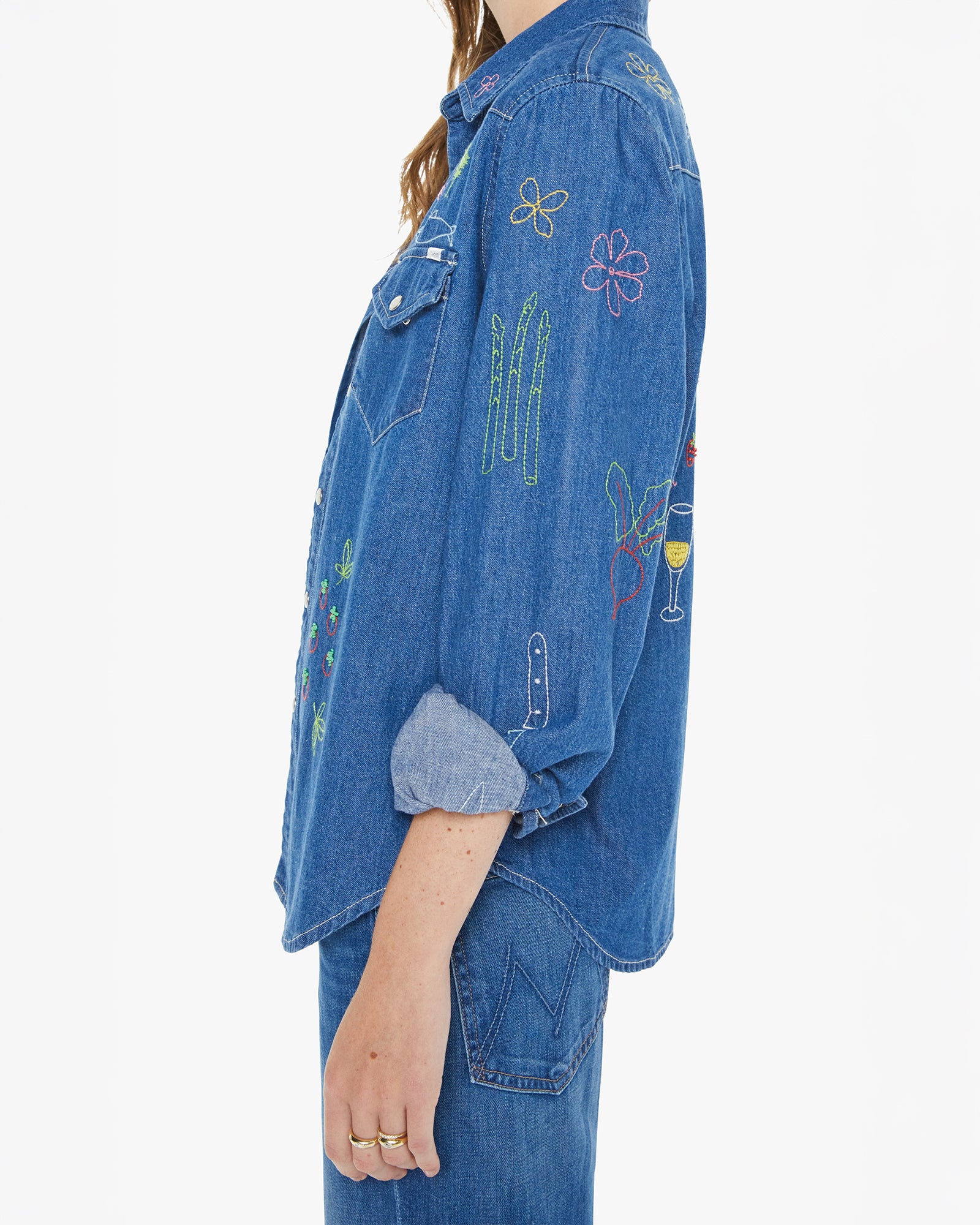 Blue denim jacket with colorful embroidery on a white background