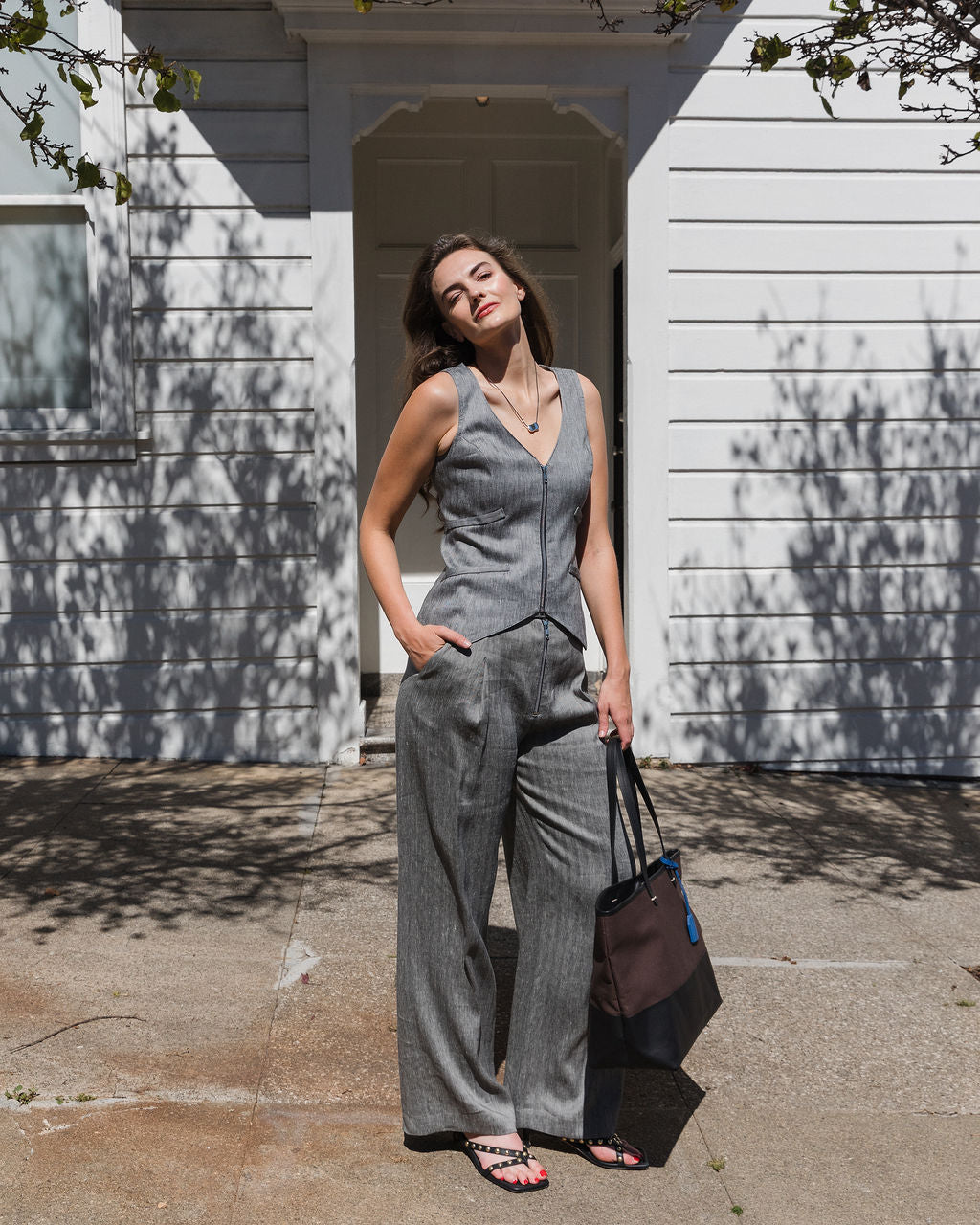 Woman in a gray suit standing outside a white building