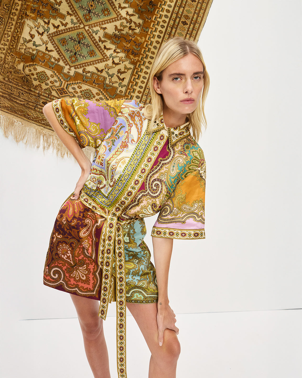 Woman wearing a colorful patterned dress with a white background