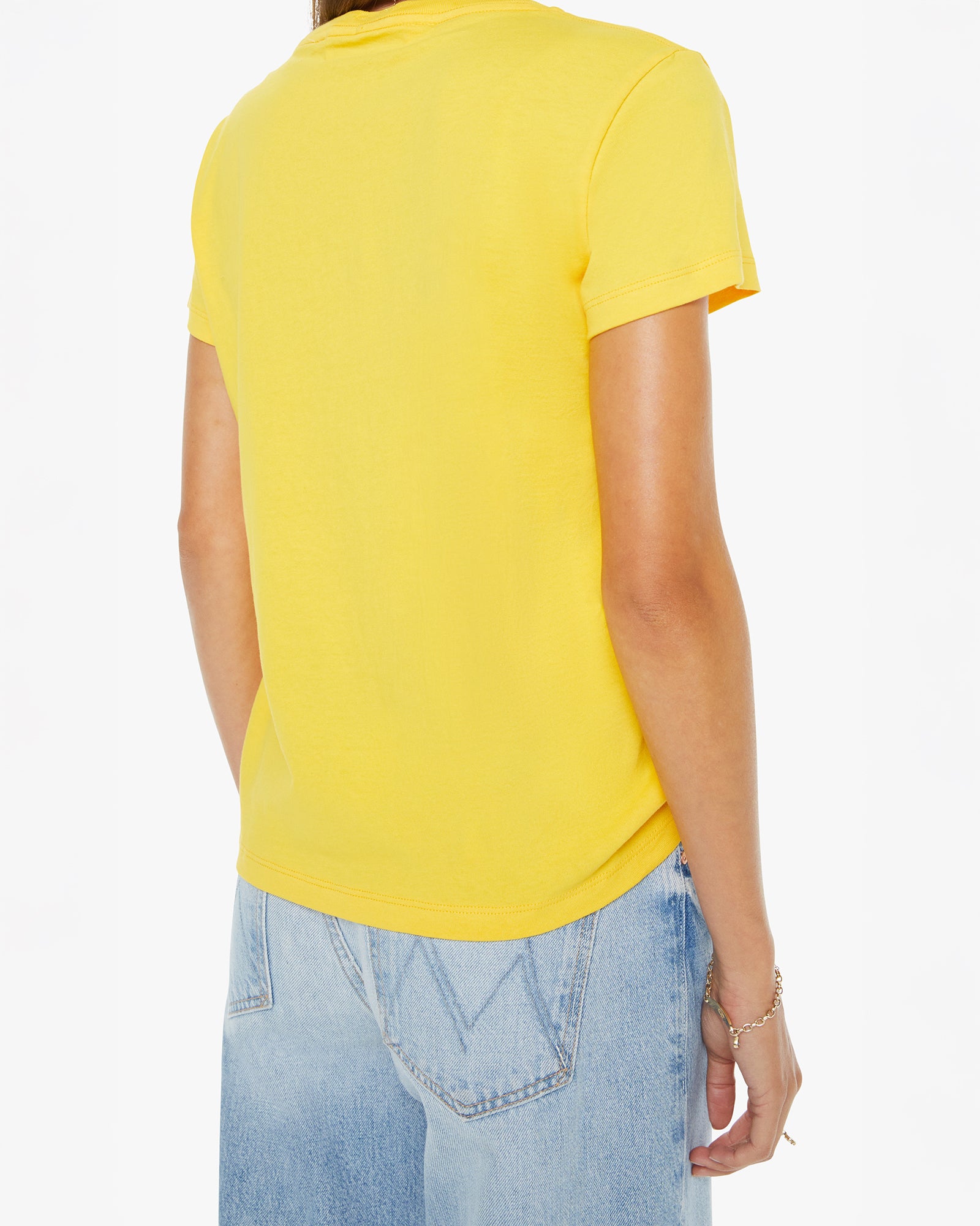 Person wearing a yellow t-shirt and light blue jeans on a white background
