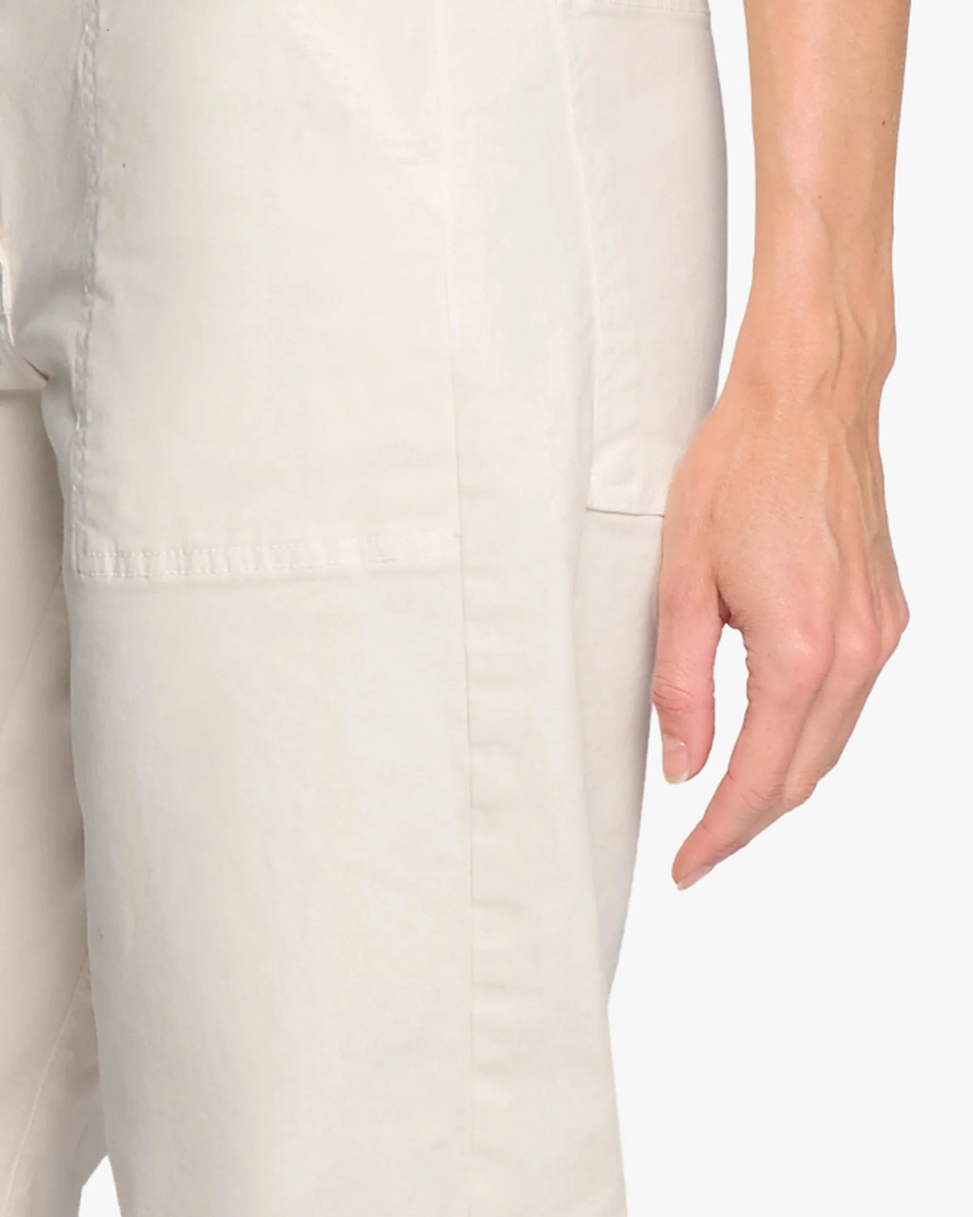 Close-up of a person wearing light-colored pants with a neutral background