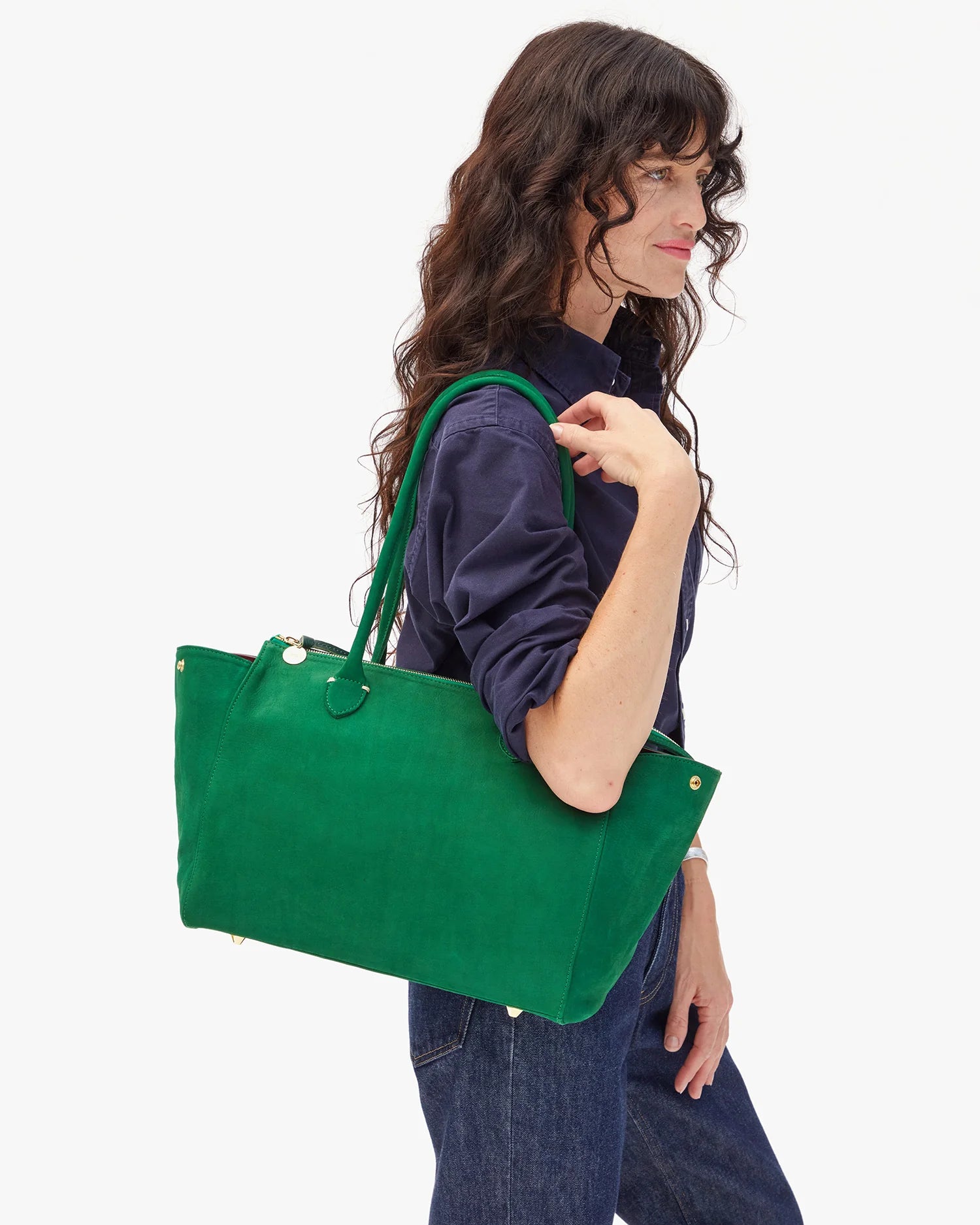 Woman holding a green tote bag against a white background