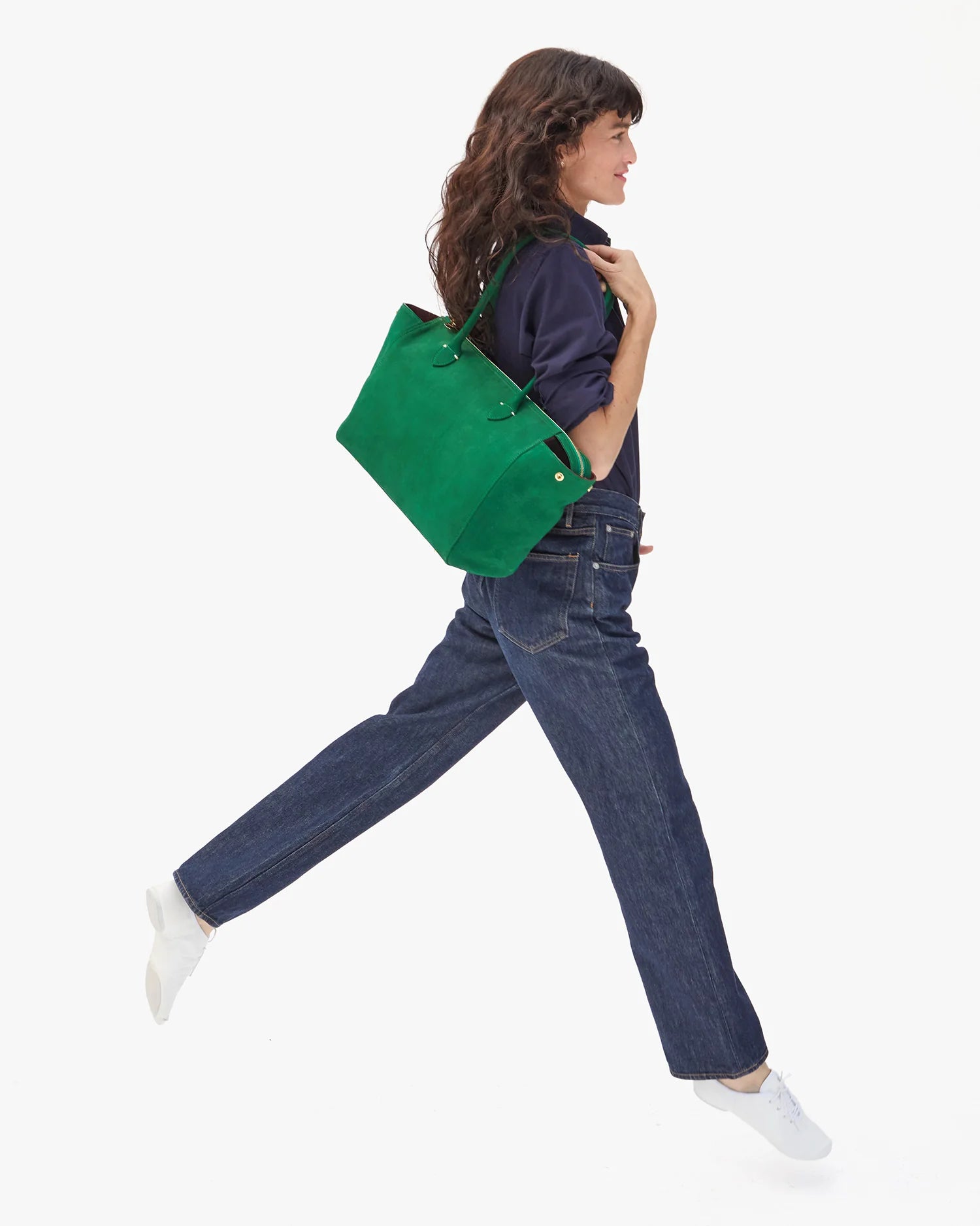 Woman walking with a green handbag on a white background
