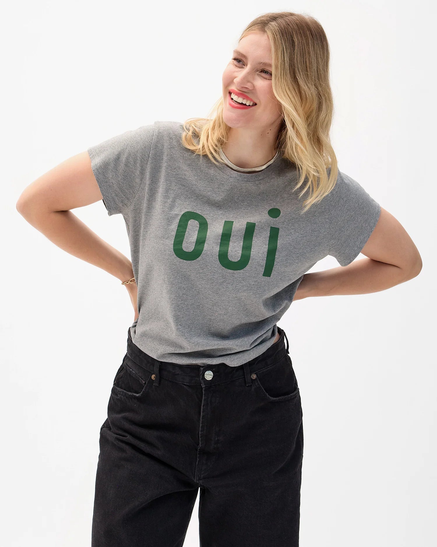 Person wearing a gray t-shirt with 'oui' printed in green on a white background