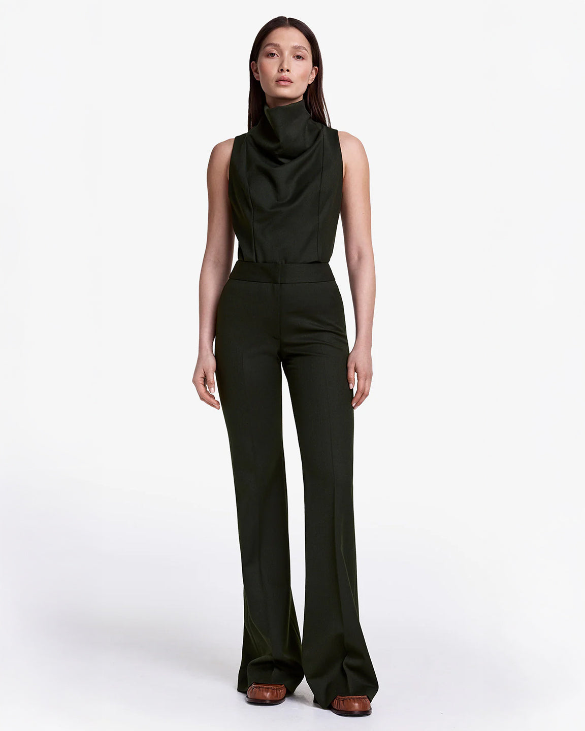 Woman wearing a black sleeveless top and pants on a white background