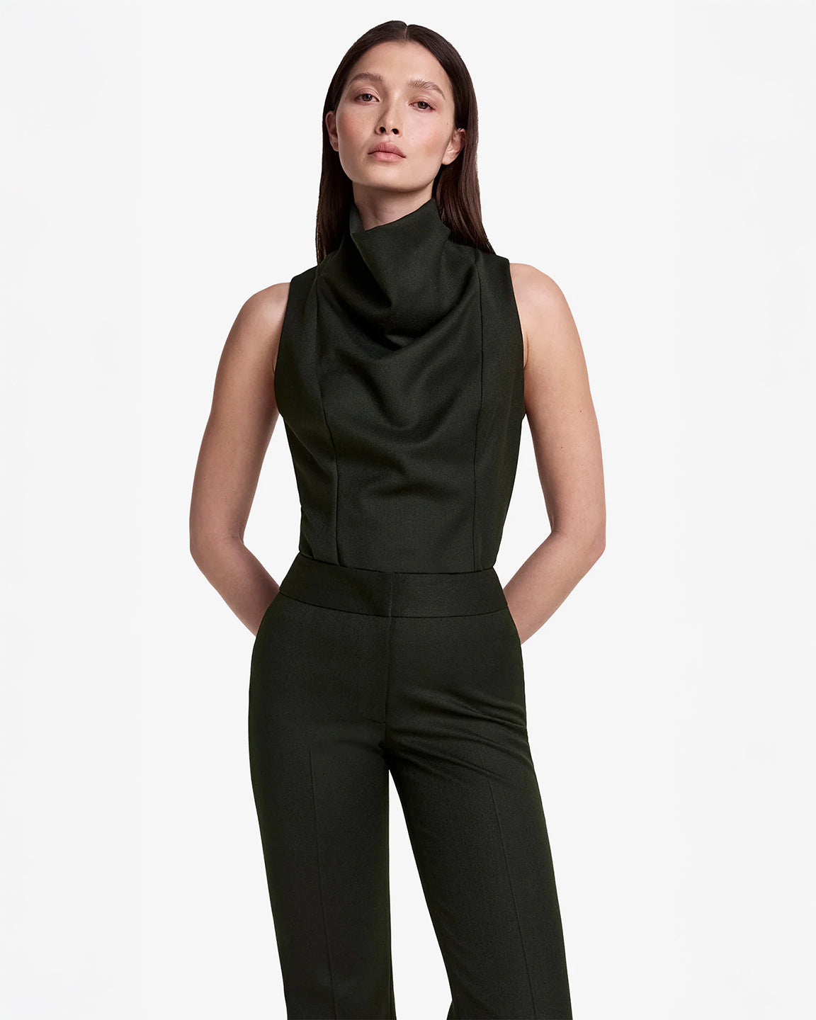 Woman wearing a black sleeveless top and pants on a white background