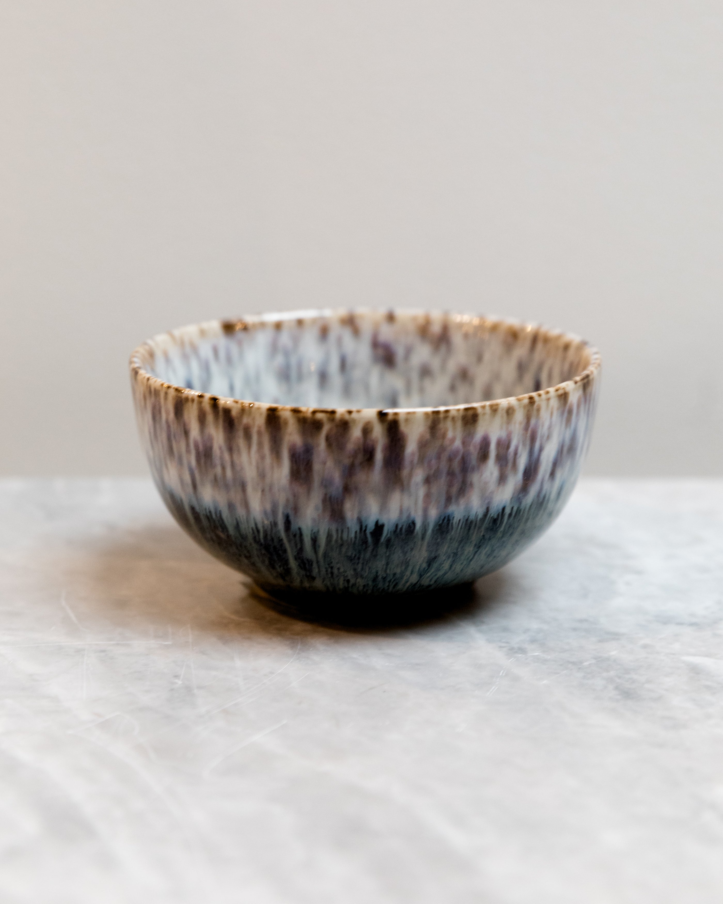 Ceramic bowl with speckled glaze on a light surface