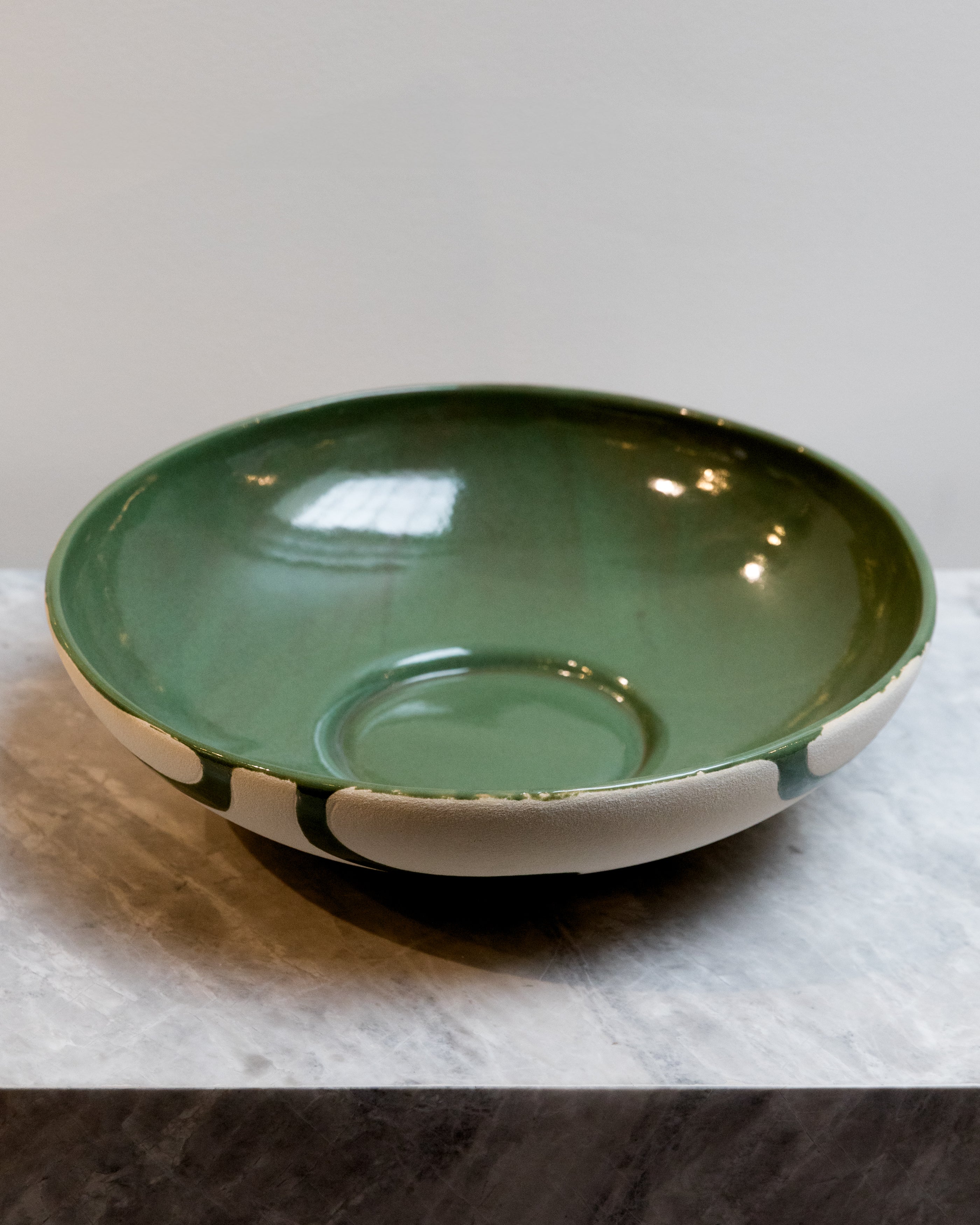 Green ceramic bowl on a marble surface