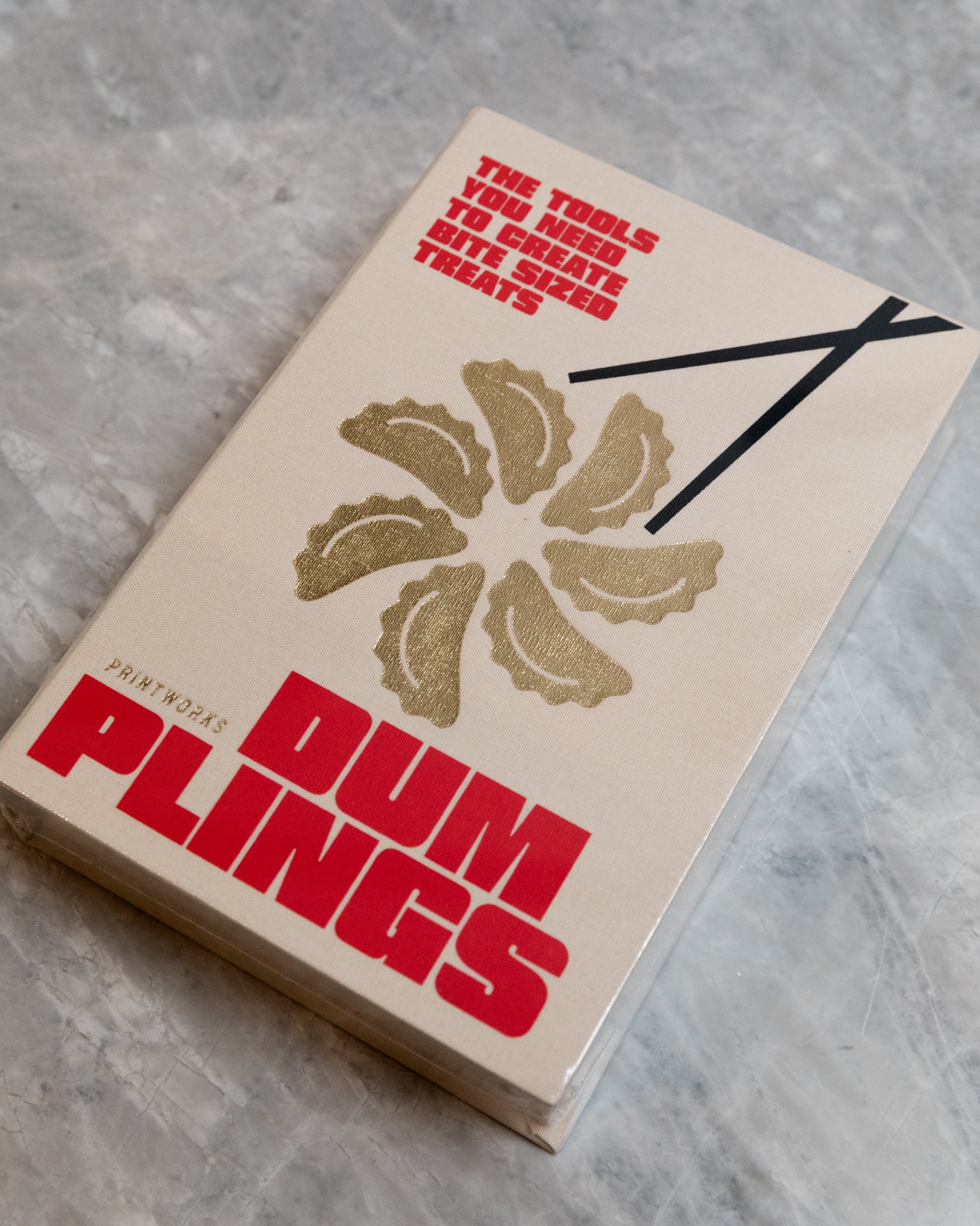 Box of tools for Dumplings with red and black text on a gray surface