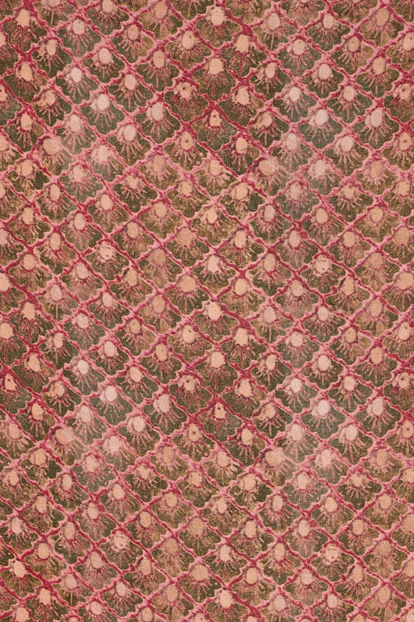 A close-up of a vintage patterned fabric featuring a repeating diamond grid design with pinkish-red lines over a brown and beige background.