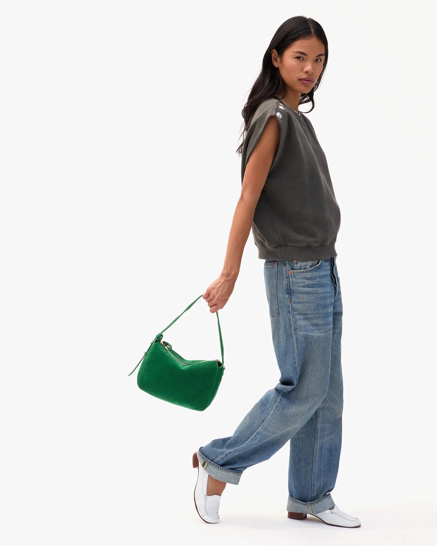 Woman holding a green handbag on a white background