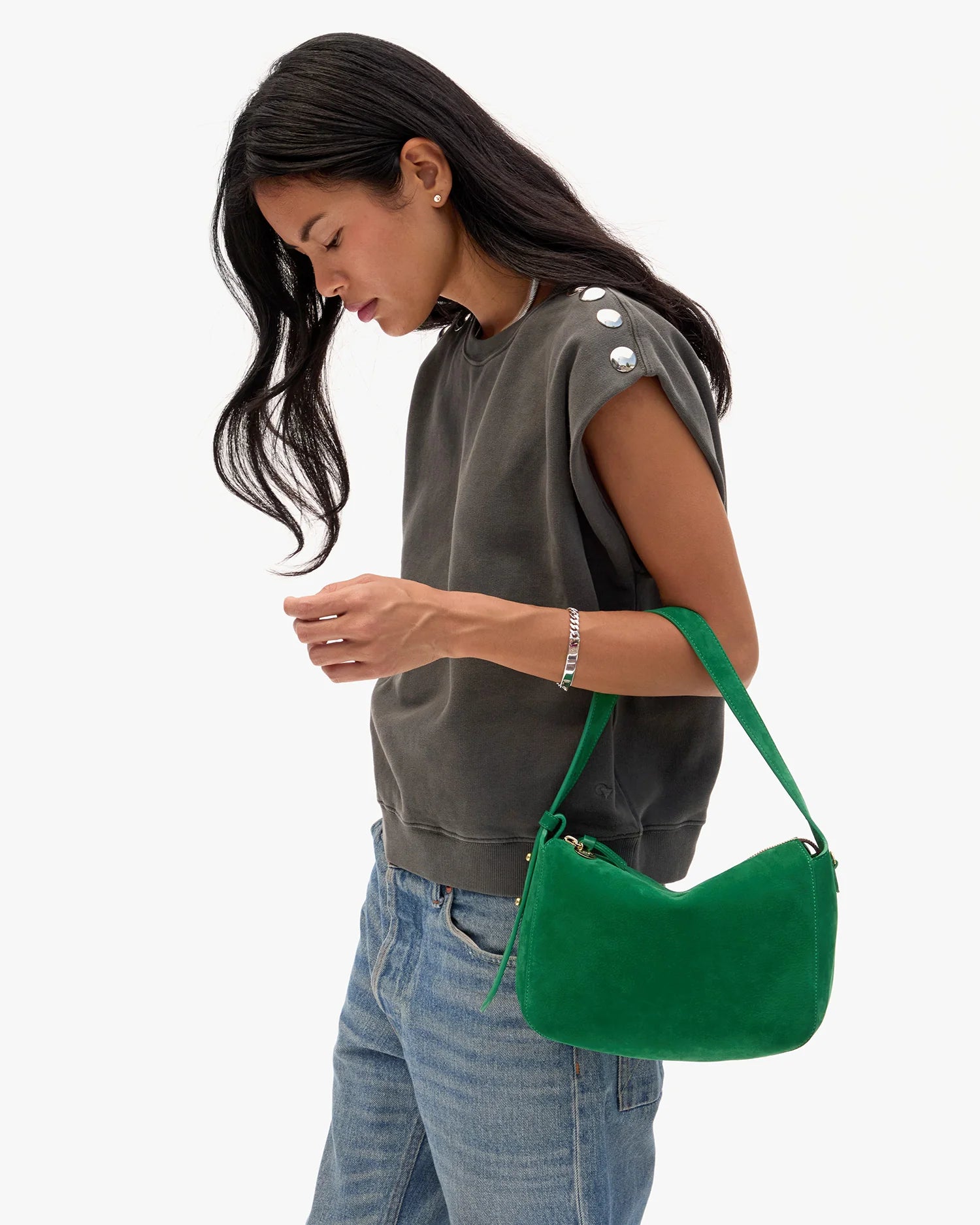 Woman holding a green handbag against a white background