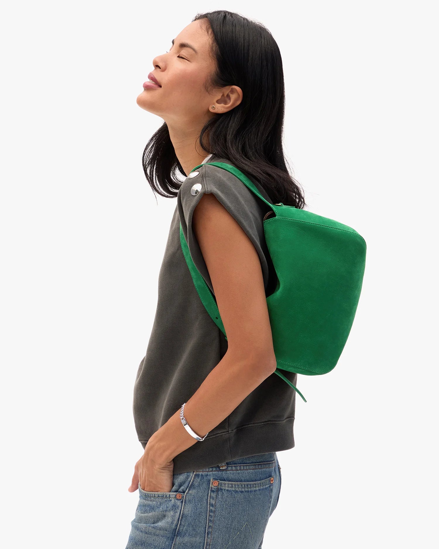 Woman wearing a green backpack on a white background