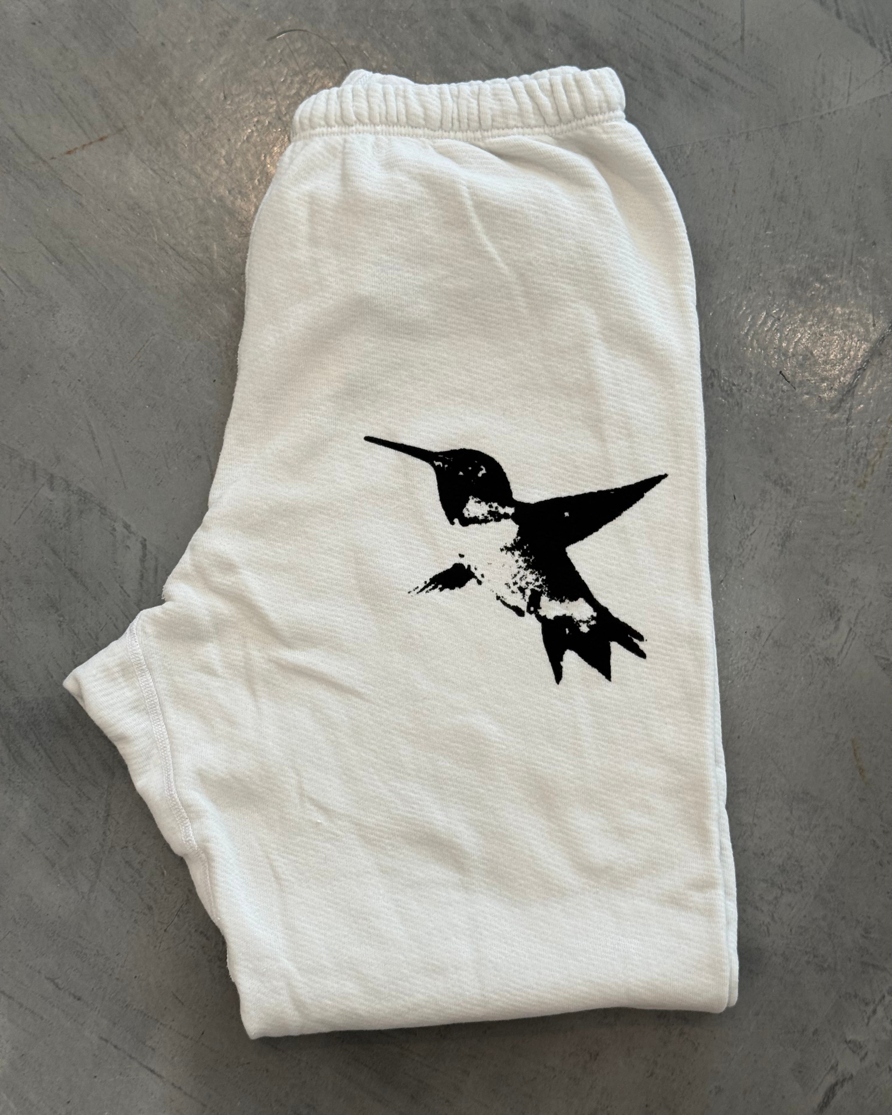 White shorts with a black bird design on a gray surface