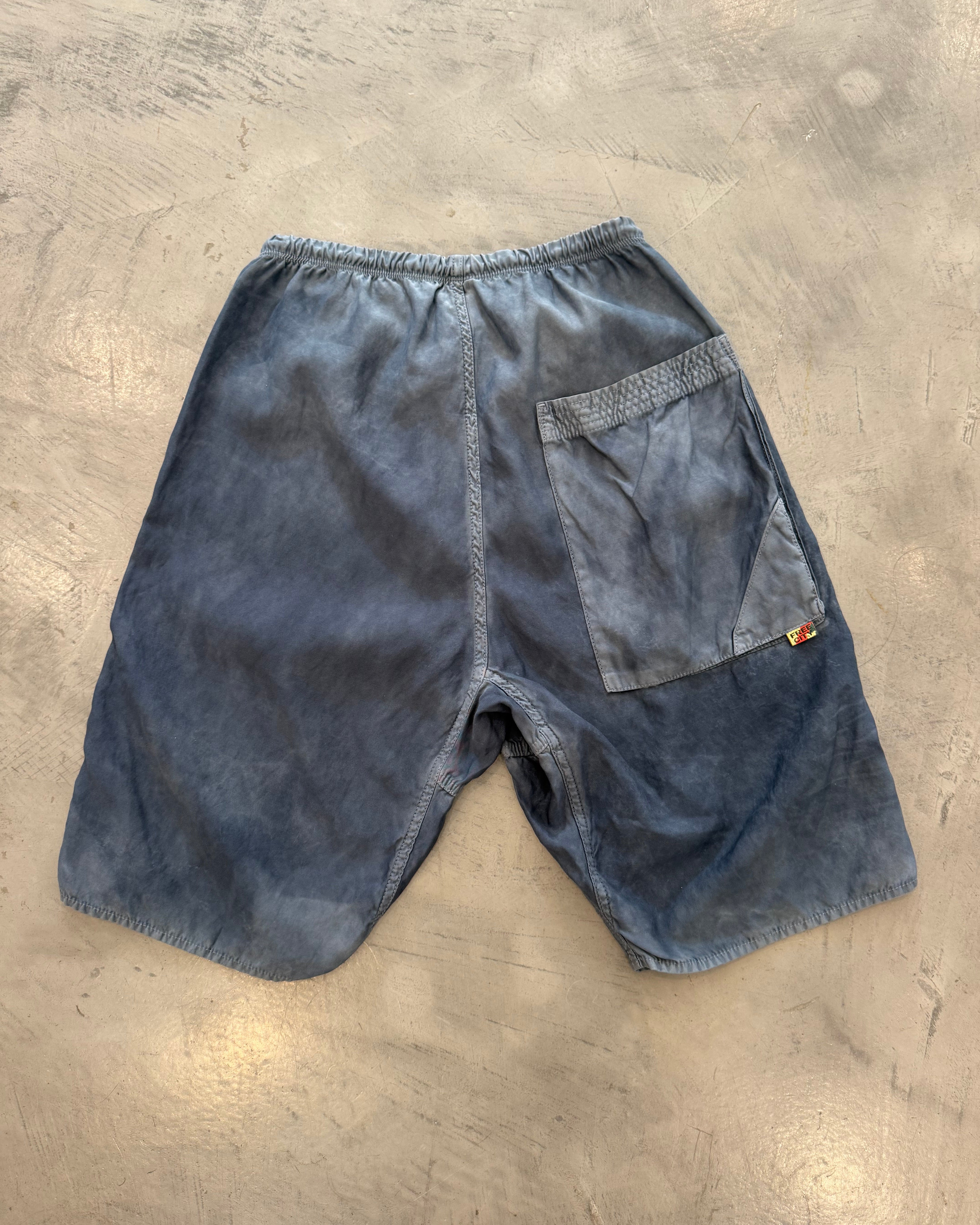 Blue denim shorts on a gray concrete surface